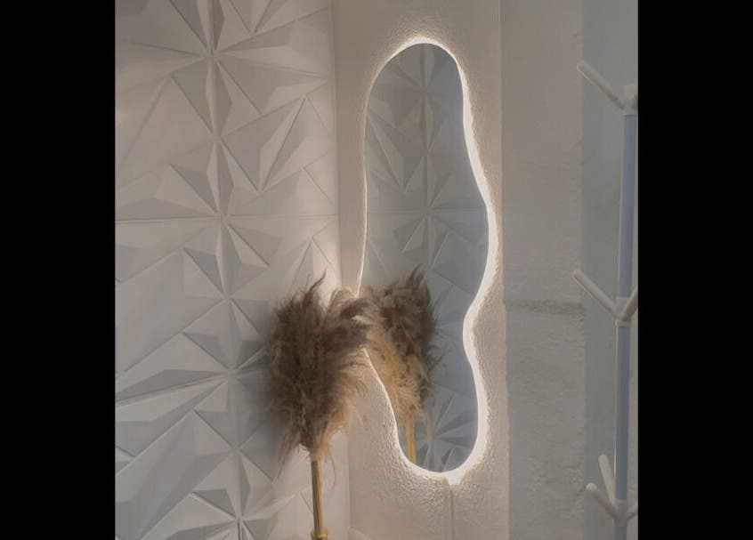 Espejo iluminado en Misfit Beauty, Quito, Pichincha, EC, destacando un diseño de pared geométrico elegante.