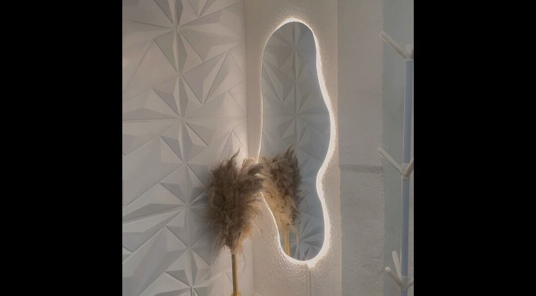 Espejo iluminado en Misfit Beauty, Quito, Pichincha, EC, destacando un diseño de pared geométrico elegante.