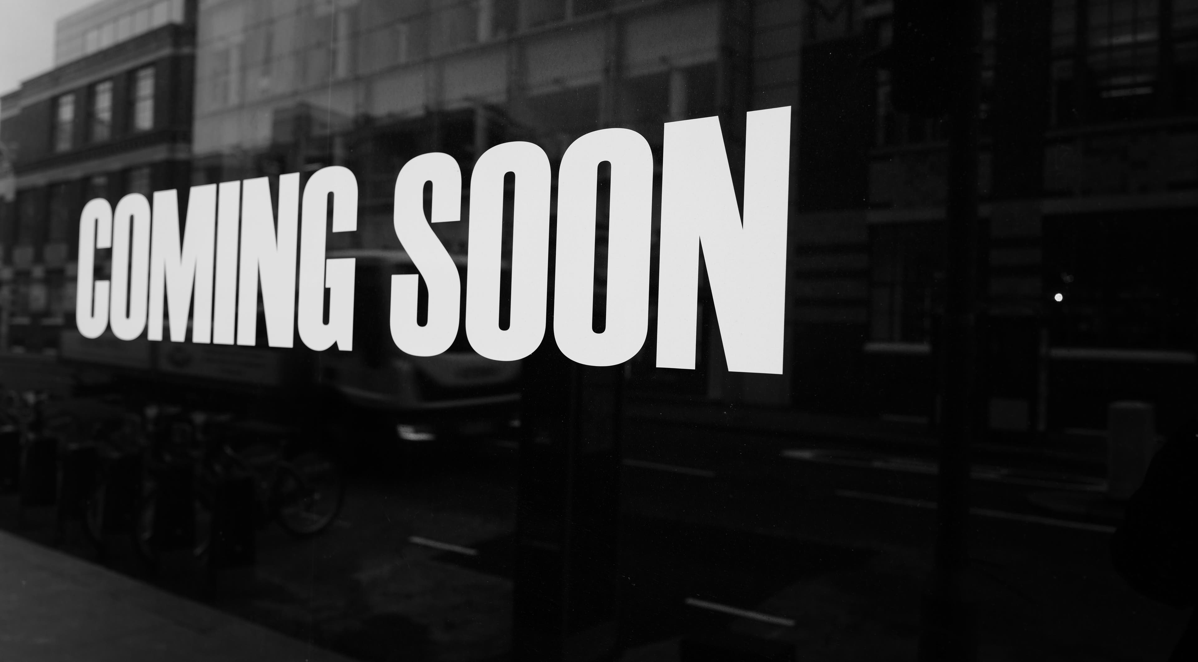 Nouvae' opening soon sign, Saint Michael, Saint Michael, BB, against city backdrop.