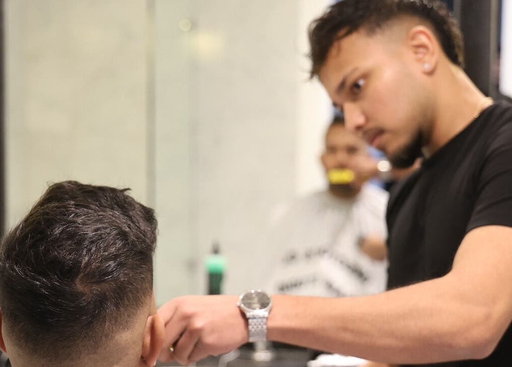 Barber at Kash & Co Barbers in Melbourne, Victoria, AU skillfully trims client's hair.