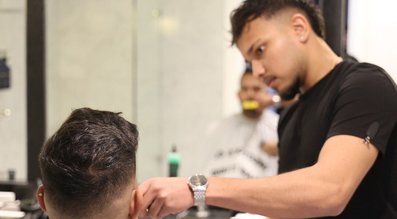 Barber at Kash & Co Barbers in Melbourne, Victoria, AU delivering a precise haircut to a client.