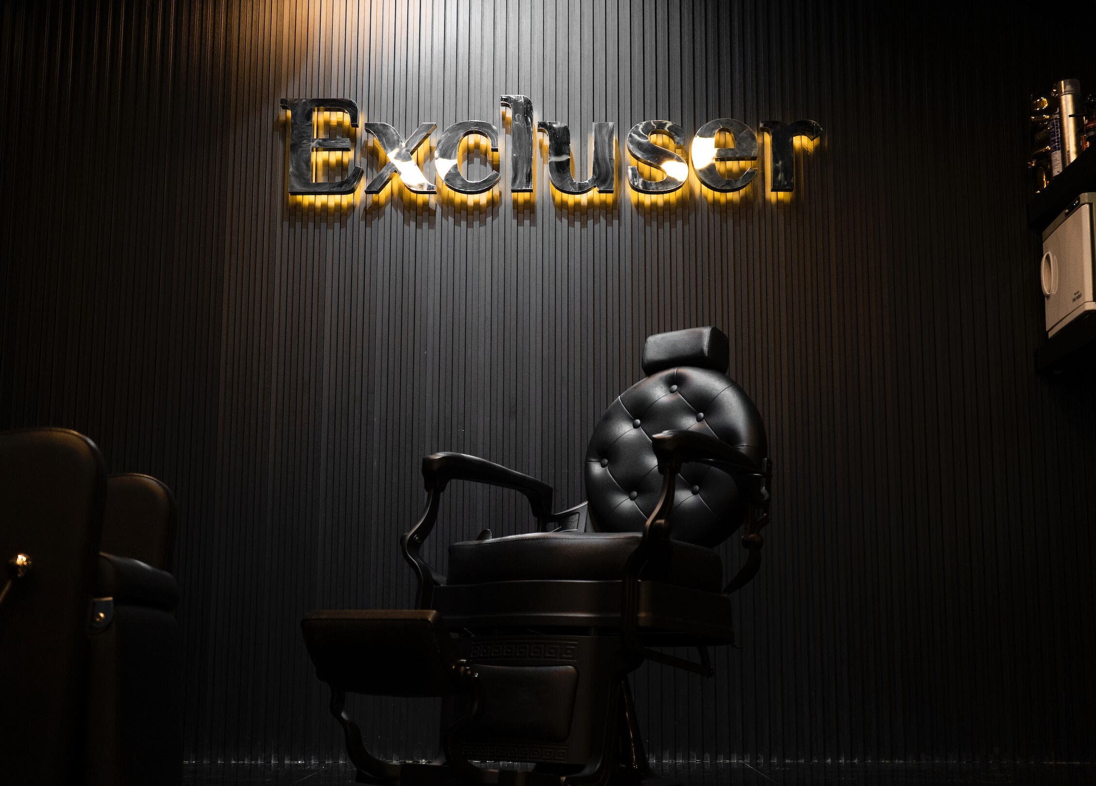 Plush barber chair at Excluser Gents Salon L.L.C, Dubai, AE. Modern interior design emphasized.