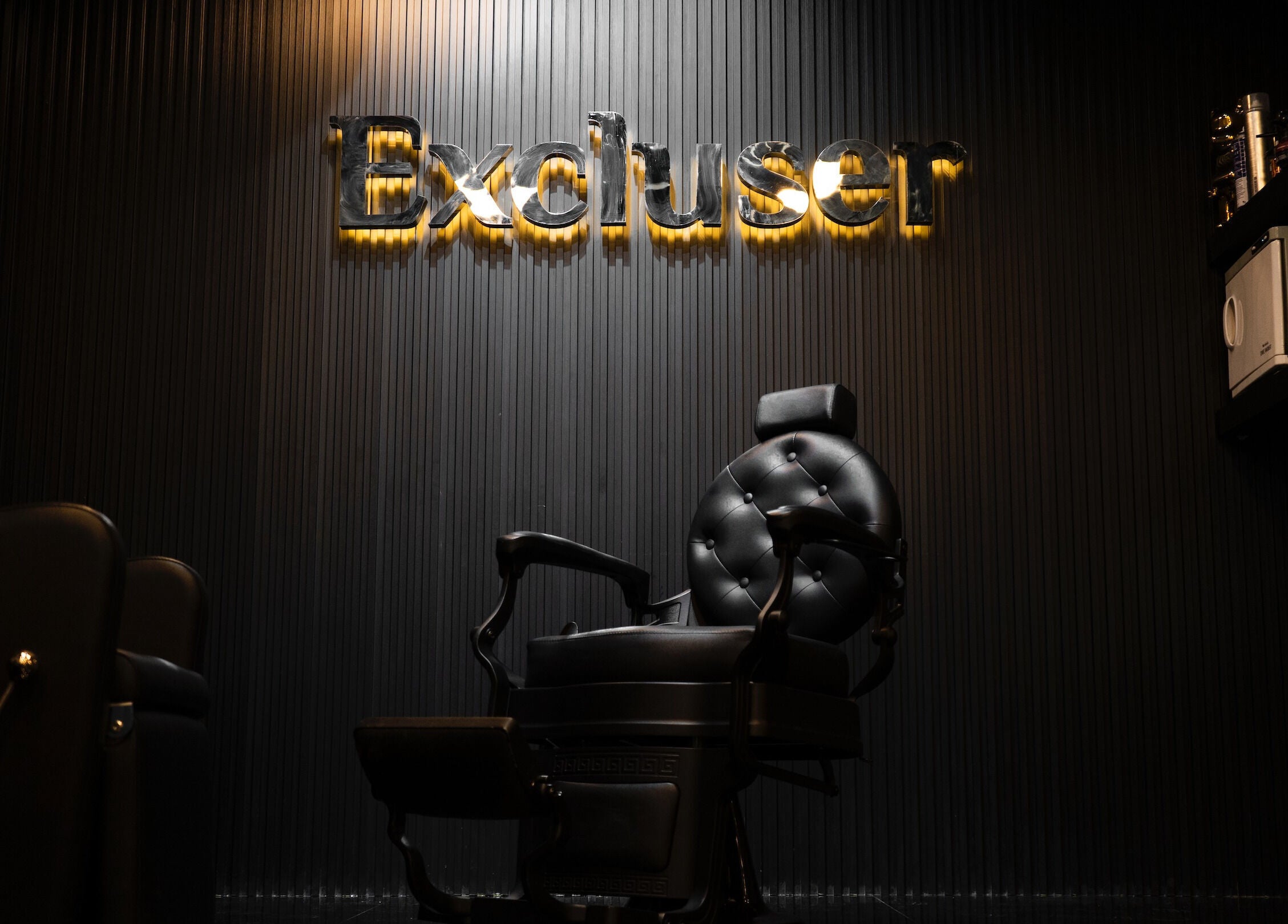 Plush barber chair at Excluser Gents Salon L.L.C, Dubai, AE. Modern interior design emphasized.