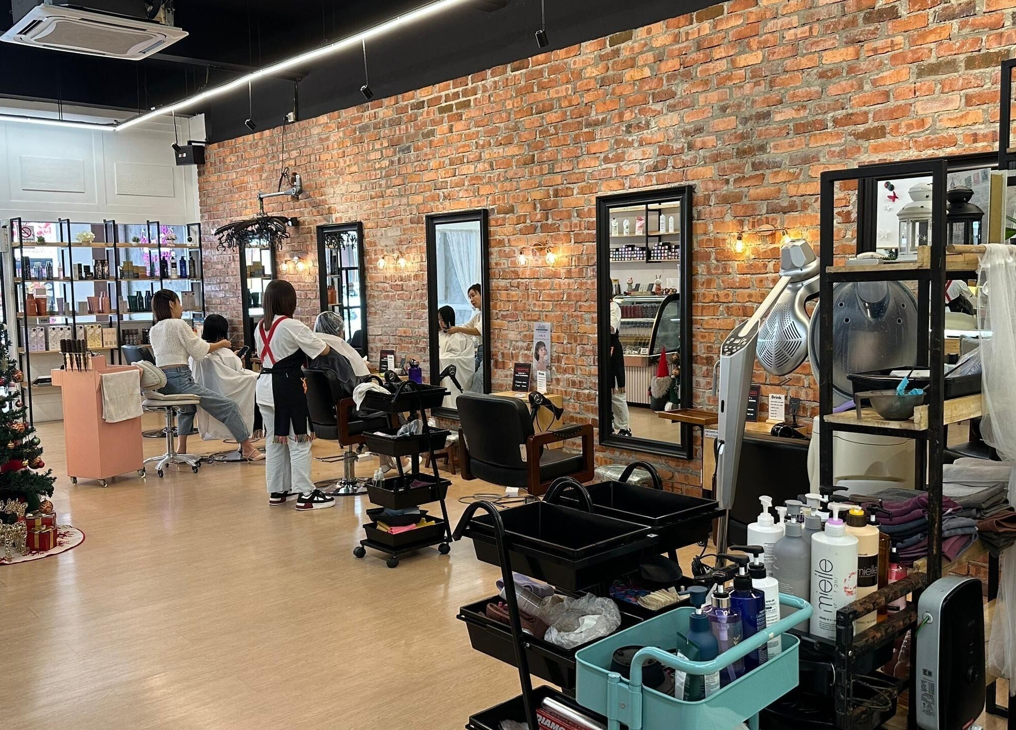 Interior of Su by jenice hair in Petaling Jaya, Selangor, MY. Stylish salon with exposed brick and sleek stations.