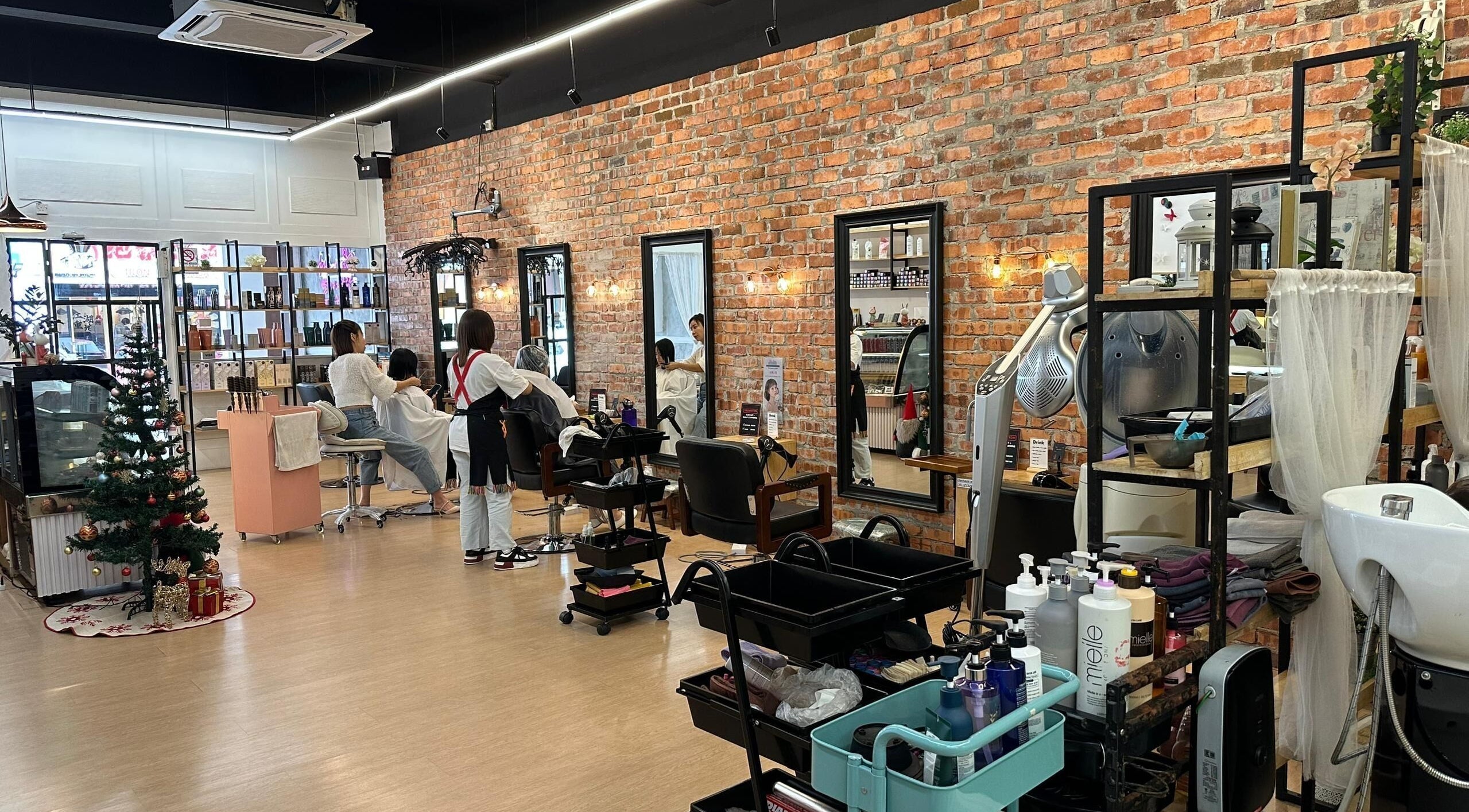 Interior of Su by jenice hair in Petaling Jaya, Selangor, MY. Stylish salon with exposed brick and sleek stations.