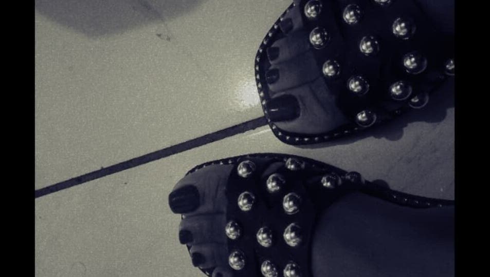 Stylish studded sandals on tiled floor at The Basic, Pretoria, Gauteng, ZA, highlighting fashion and elegance.
