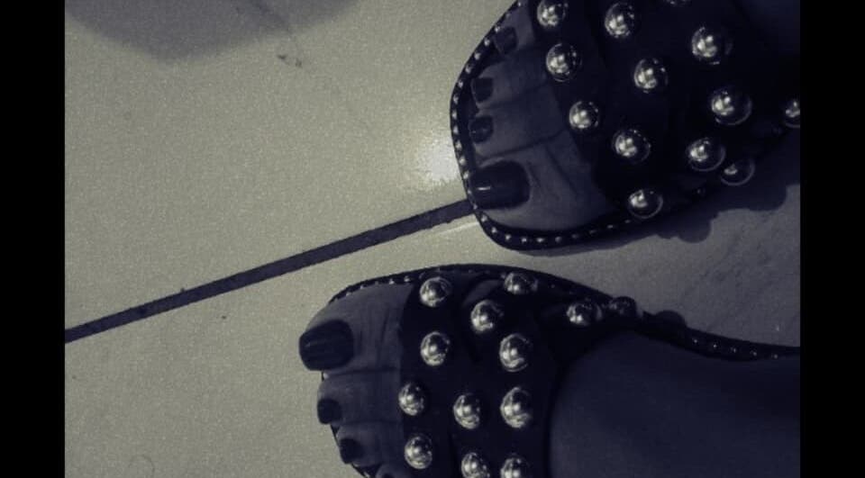 Stylish studded sandals on tiled floor at The Basic, Pretoria, Gauteng, ZA, highlighting fashion and elegance.