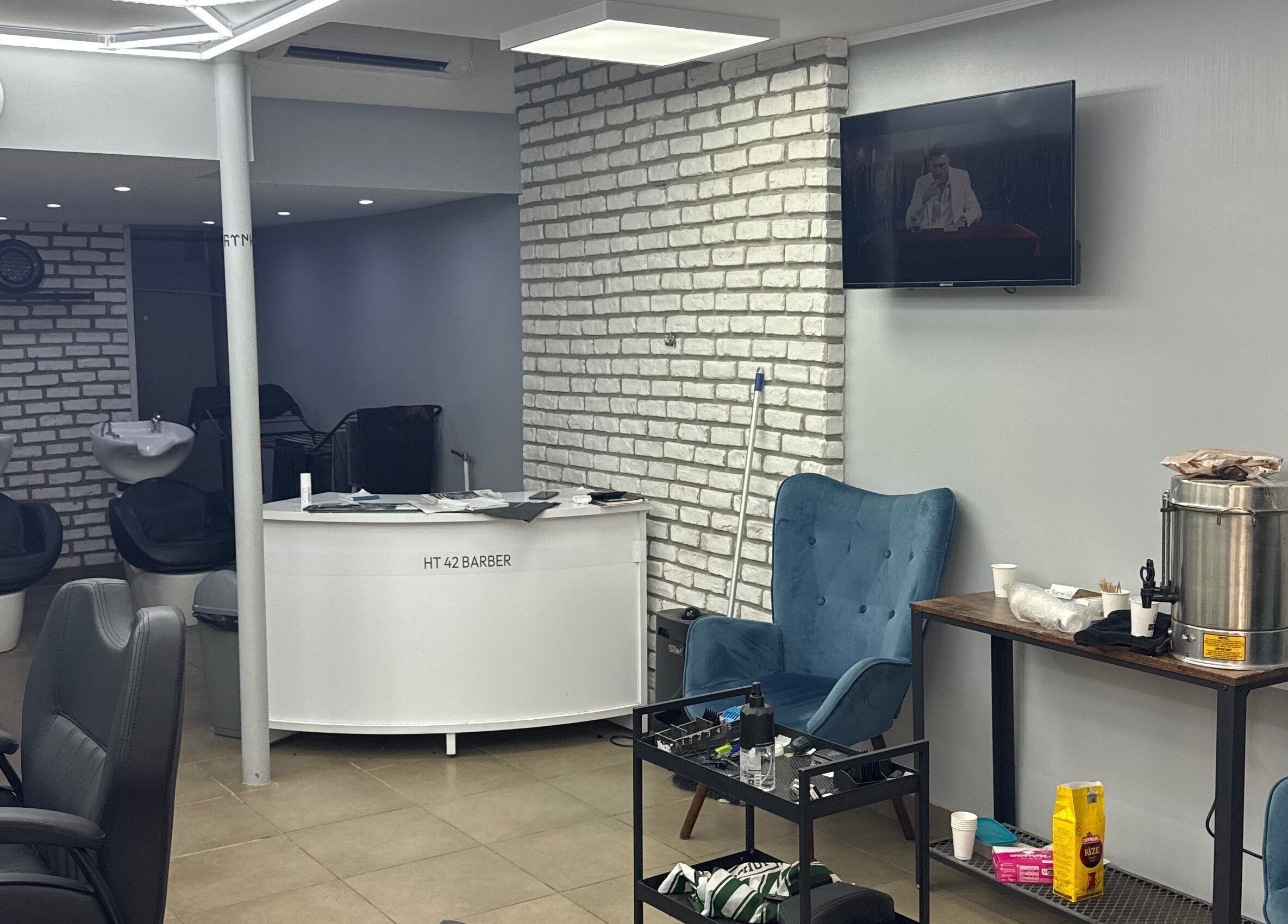 Intérieur du salon Chez gotenks / Semih à Saint-priest, Auvergne-rhône-alpes, avec fauteuils et espace de lavage.