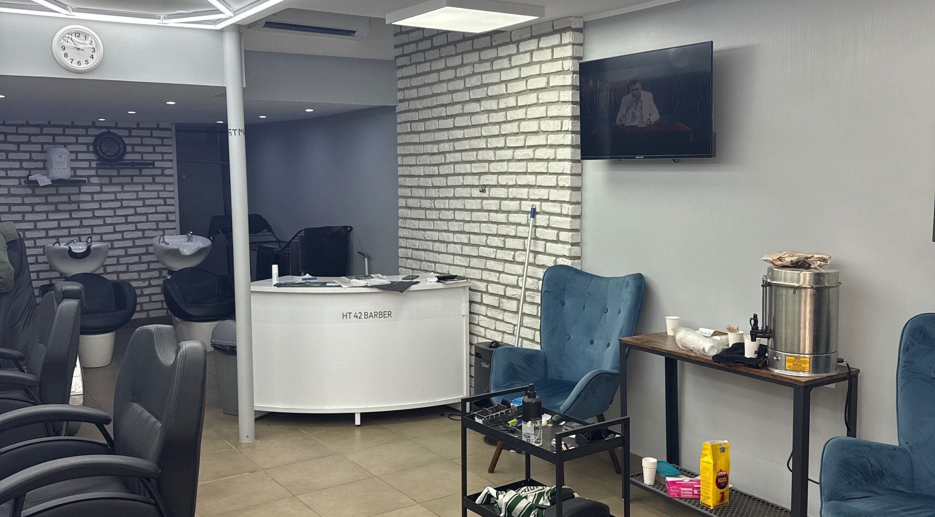 Intérieur du salon Chez gotenks / Semih à Saint-priest, Auvergne-rhône-alpes, avec fauteuils et espace de lavage.
