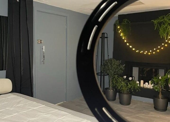 Комната в салоне Onetouch, Лондон, Англия, украшенная растениями и гирляндой.