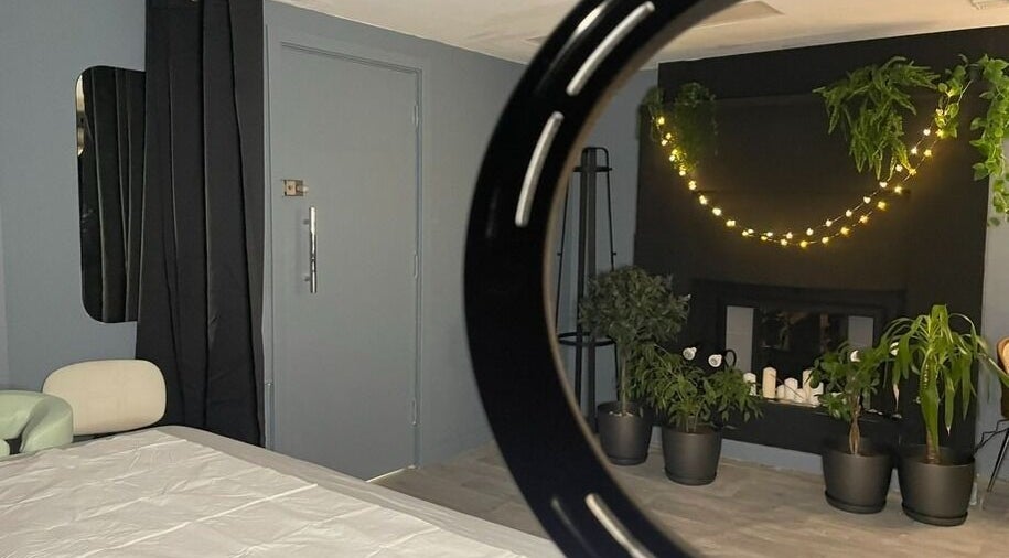 Комната в салоне Onetouch, Лондон, Англия, украшенная растениями и гирляндой.