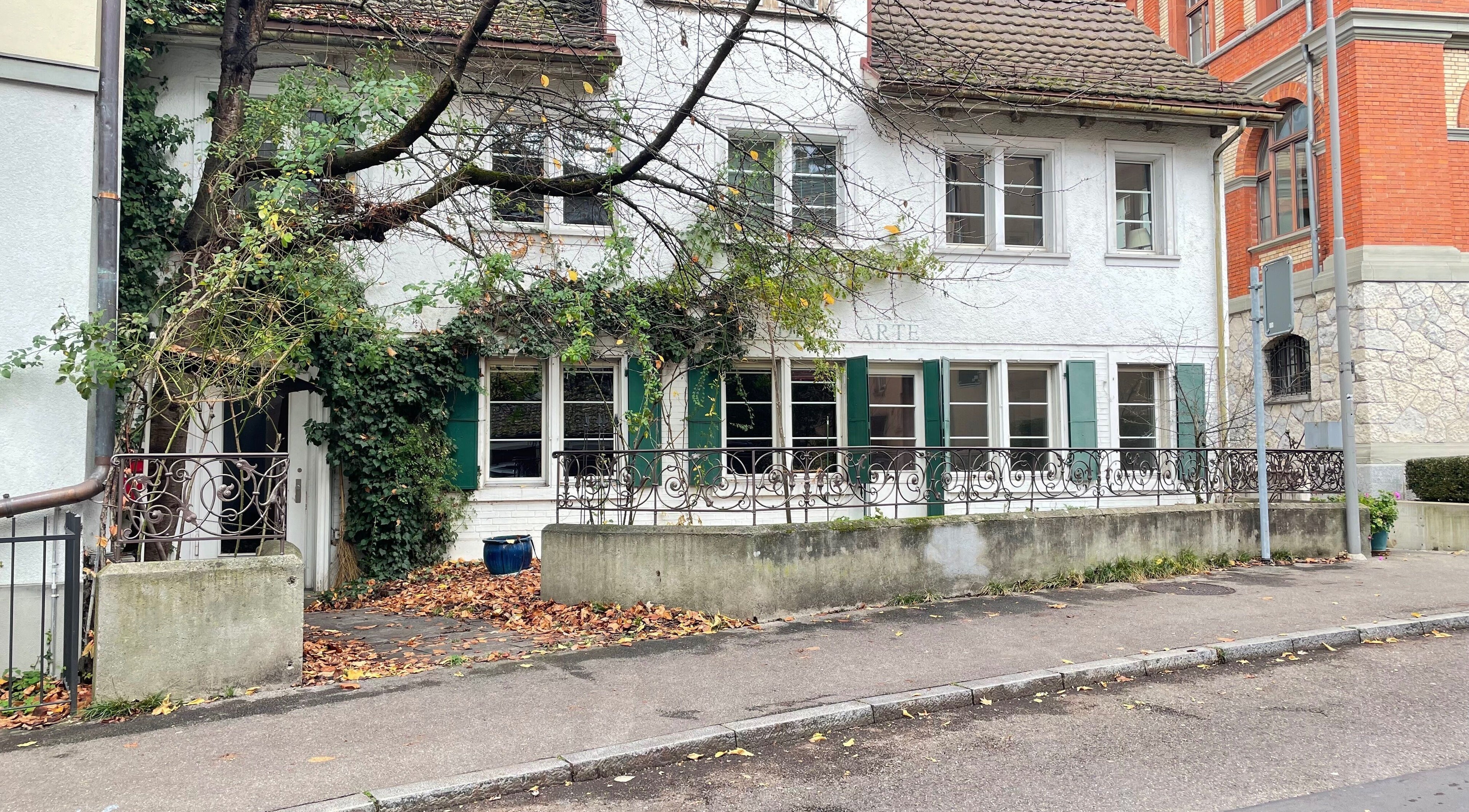 Facciata incantevole di Lab.23 Barbershop a Zürich, Zürich, CH, immersa nel verde e foglie autunnali.