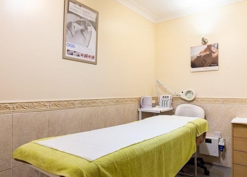 Calm treatment room at Elite Cosmetology, London, England, GB, featuring a treatment bed and equipment.