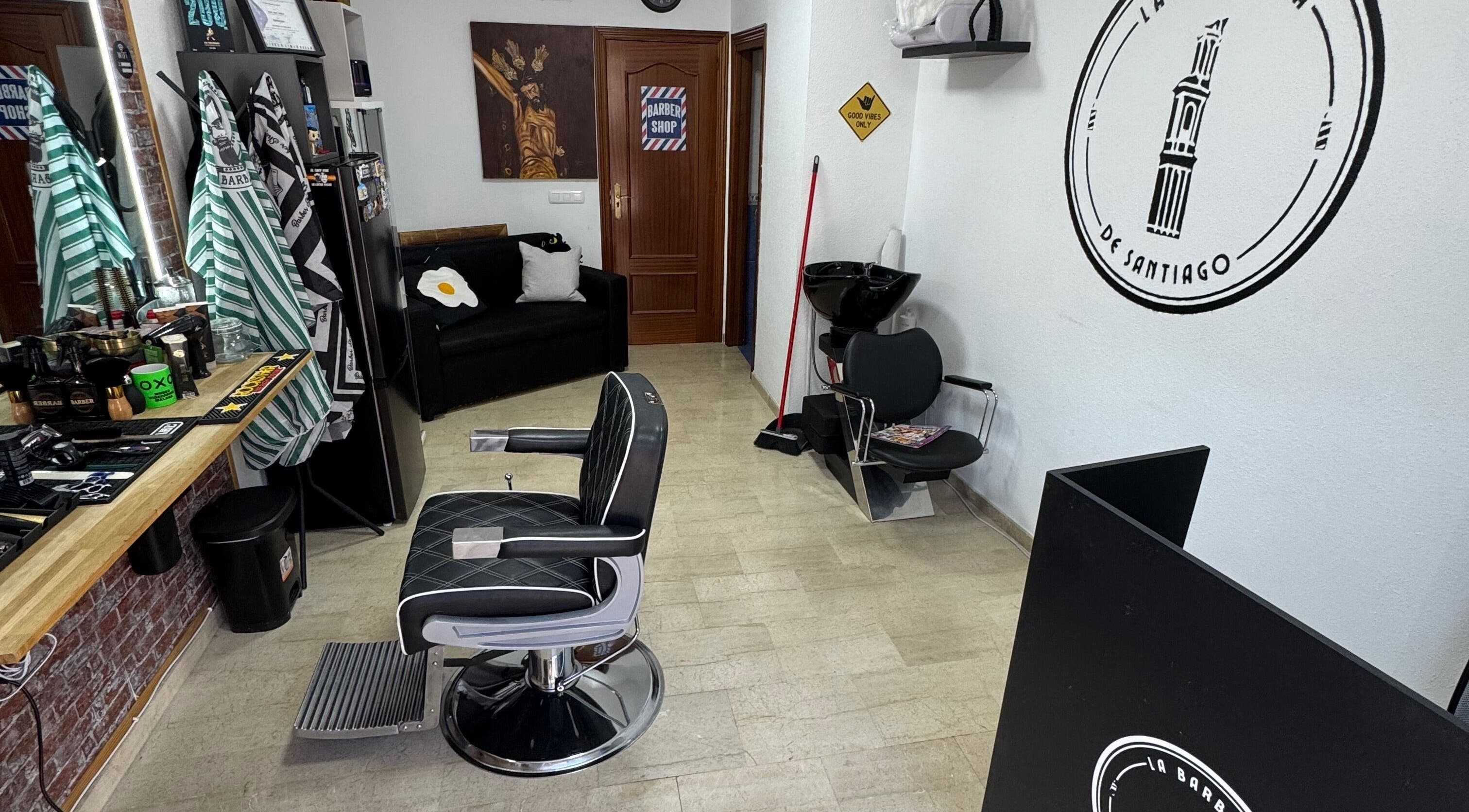 Interior de La Barbería de Santiago, Lucena, Andalucía, ES, con decoración moderna y sillón de barbero.