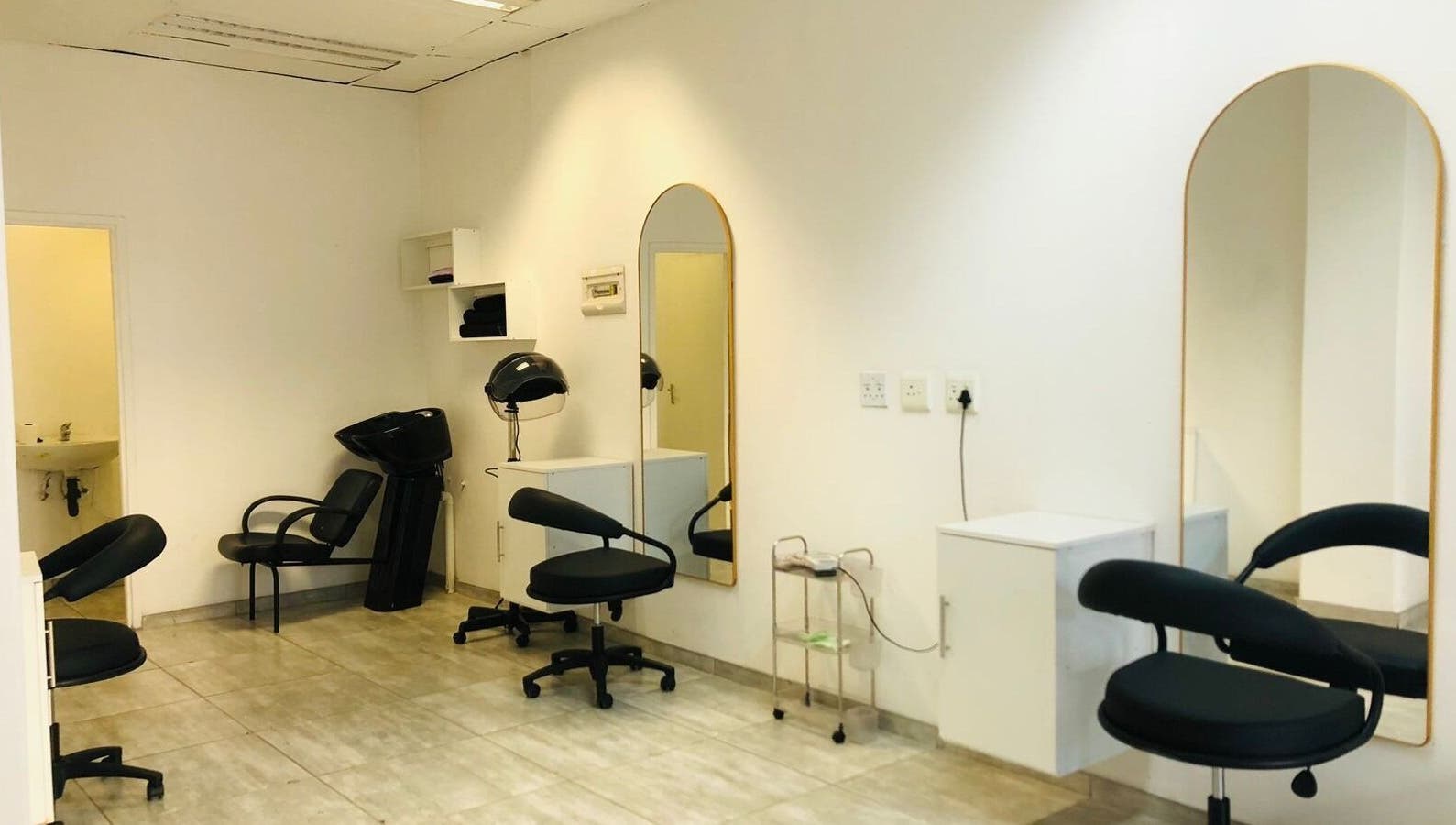 Chic interior of Glamour Groove Hair Lounge, Johannesburg, Gauteng, ZA, featuring modern salon chairs and mirrors.