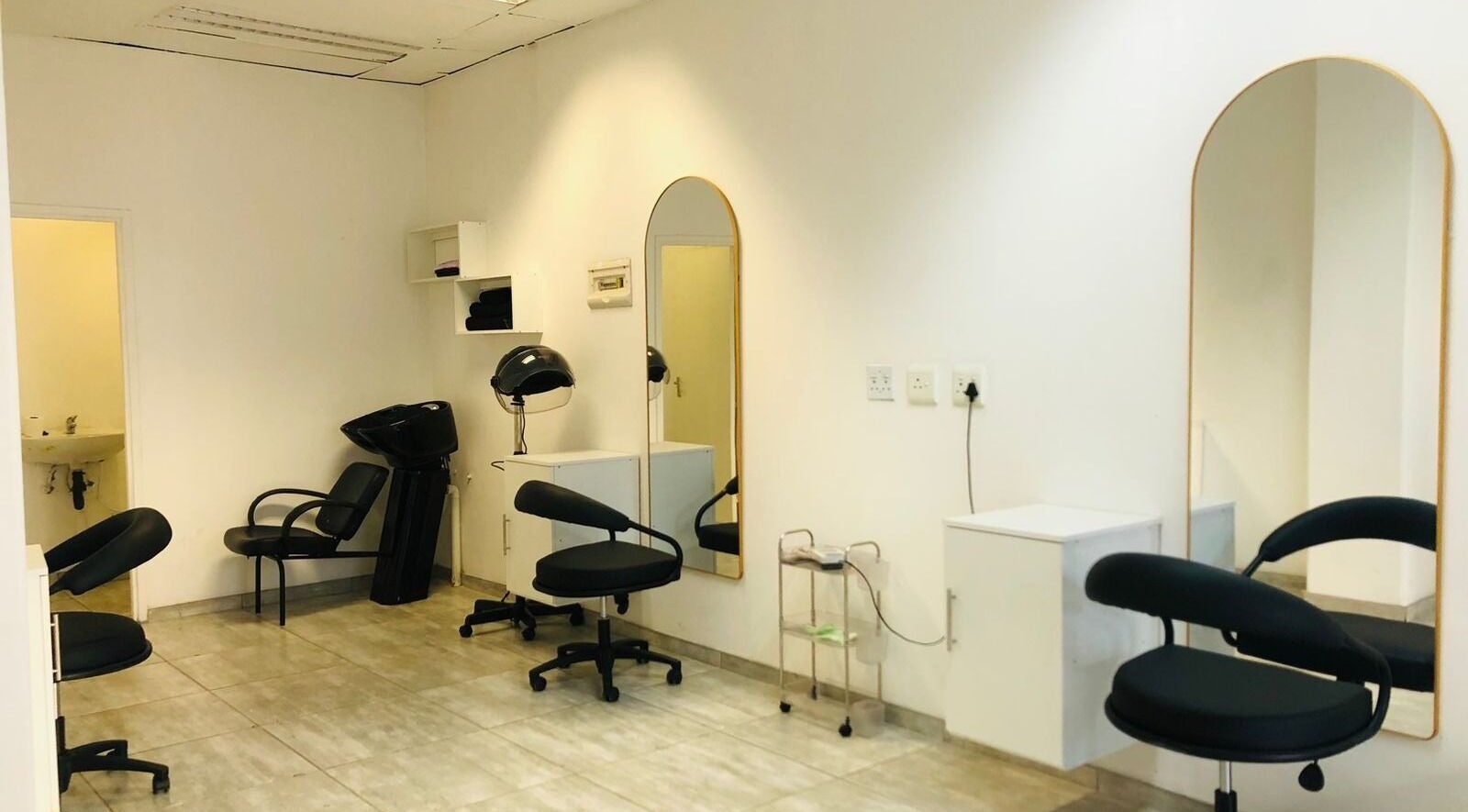 Chic interior of Glamour Groove Hair Lounge, Johannesburg, Gauteng, ZA, featuring modern salon chairs and mirrors.