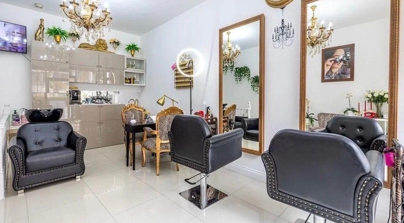 Sophisticated interior of TT Hair And Beauty Academy, London, England, GB with plush chairs and golden mirrors.