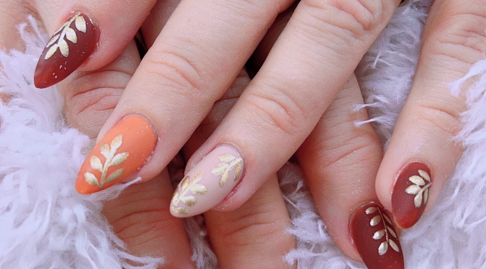 Móng tay nghệ thuật tại Julie's Nails Salon, Brick Township, New Jersey, US, với thiết kế lá vàng.