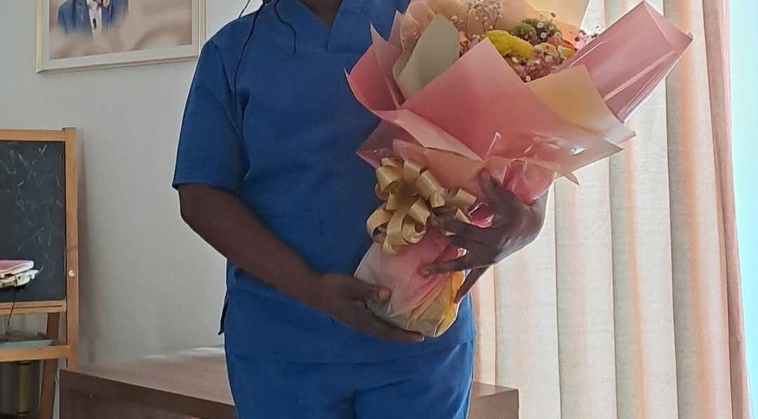 Staff holding bouquet at Mariam Massage, muscat, OM, symbolizing warmth and care in wellness service.