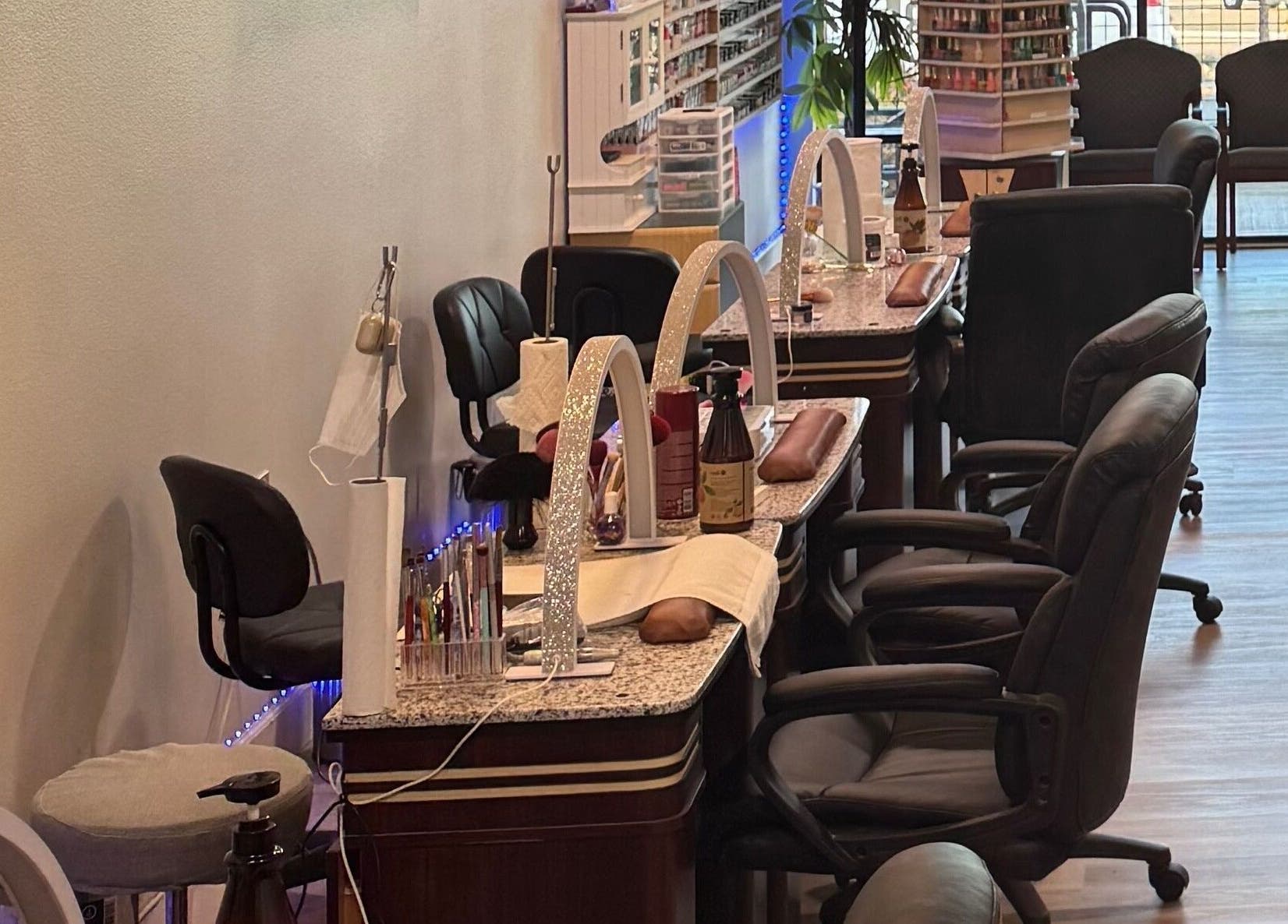 Elegant nail stations at HD Nails, Portland, Oregon, US, featuring modern chairs and polish displays.