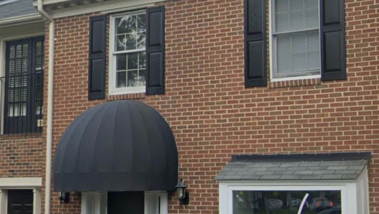 Entrance to LASH ME & MORE in Vienna, Virginia, showcasing elegant brick exterior and black awnings.