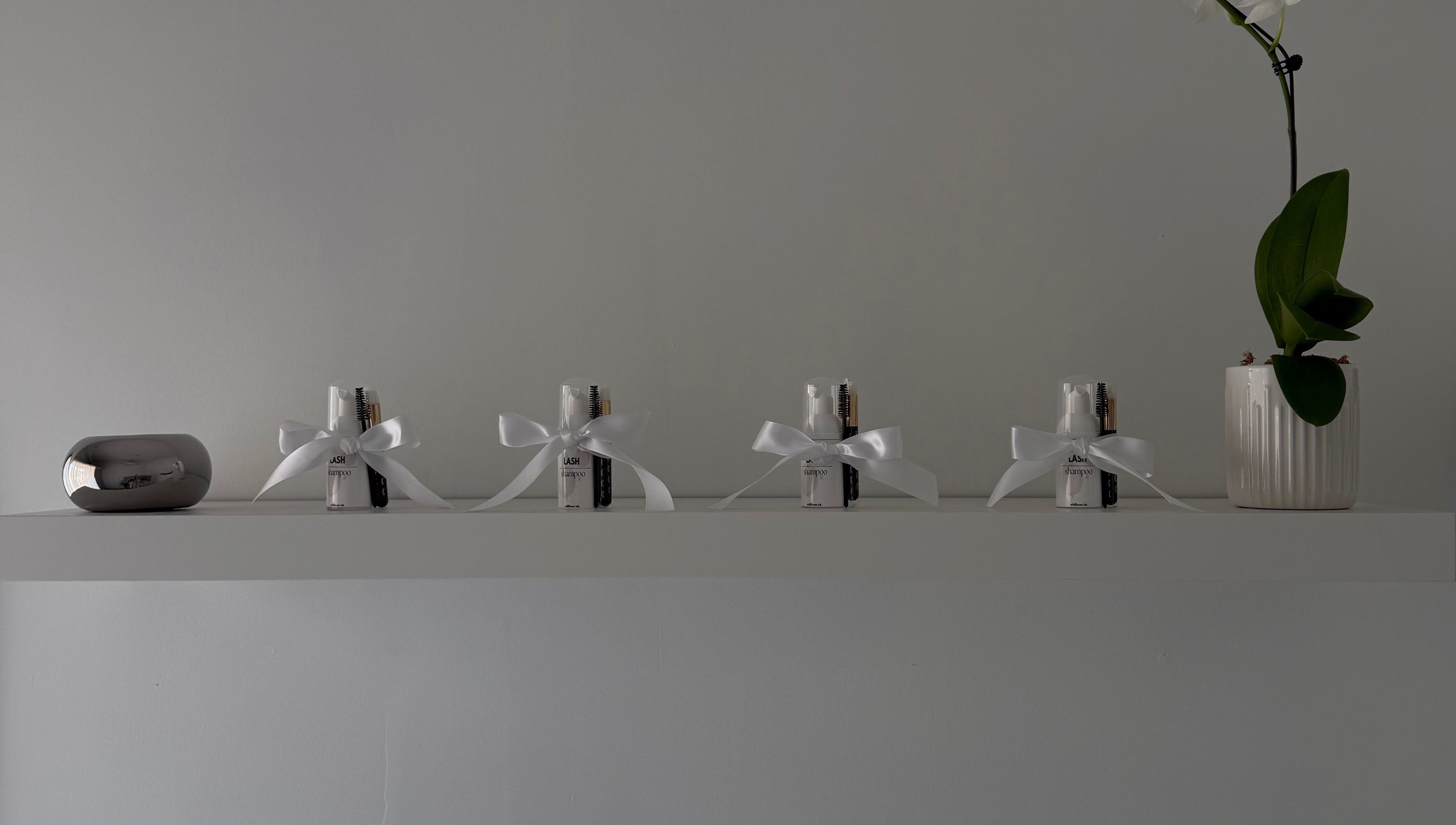 Elegant shelf at Wildflower Ink, Mount Hawthorn, Western Australia, with beauty kits and an orchid arrangement.