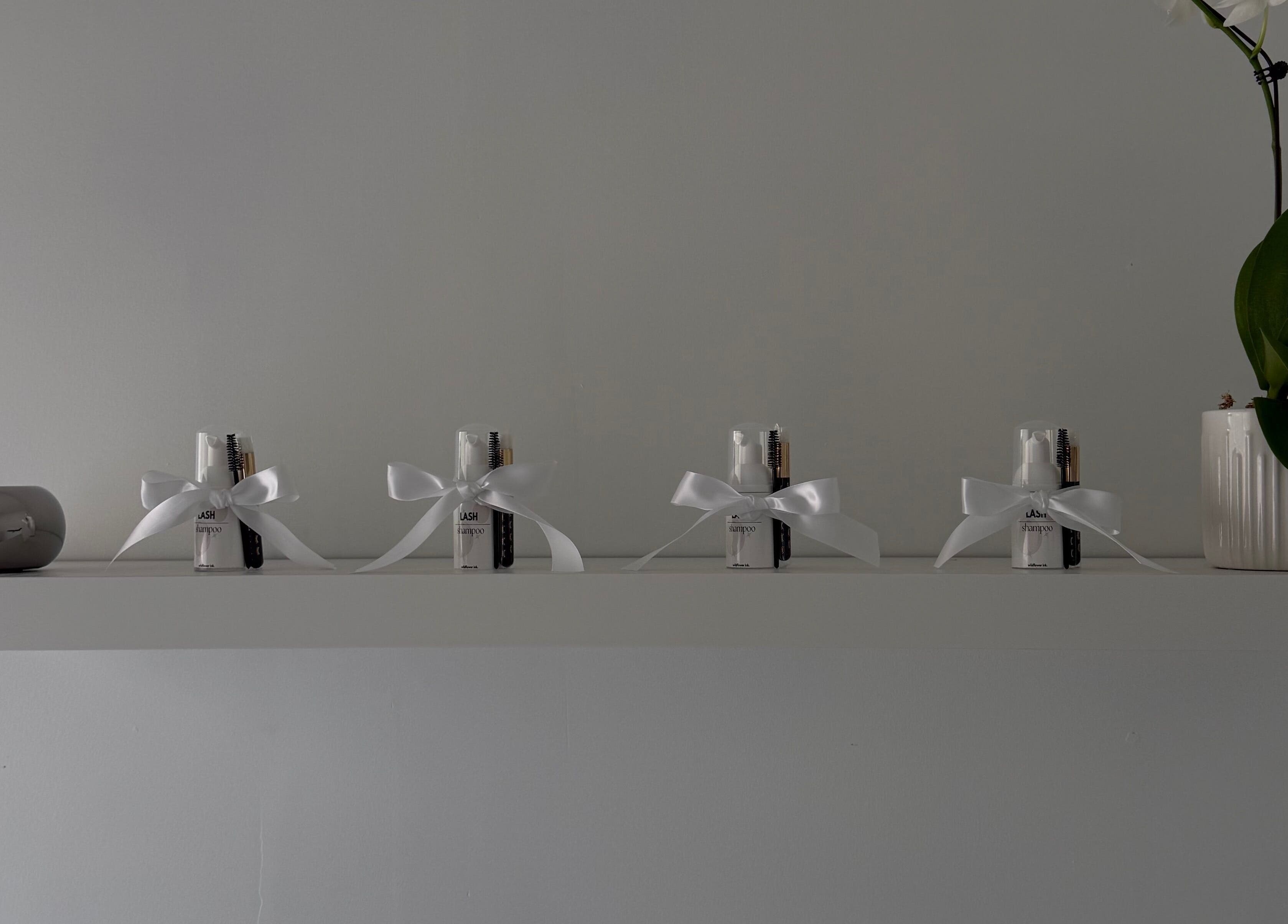 Elegant shelf at Wildflower Ink, Mount Hawthorn, Western Australia, with beauty kits and an orchid arrangement.