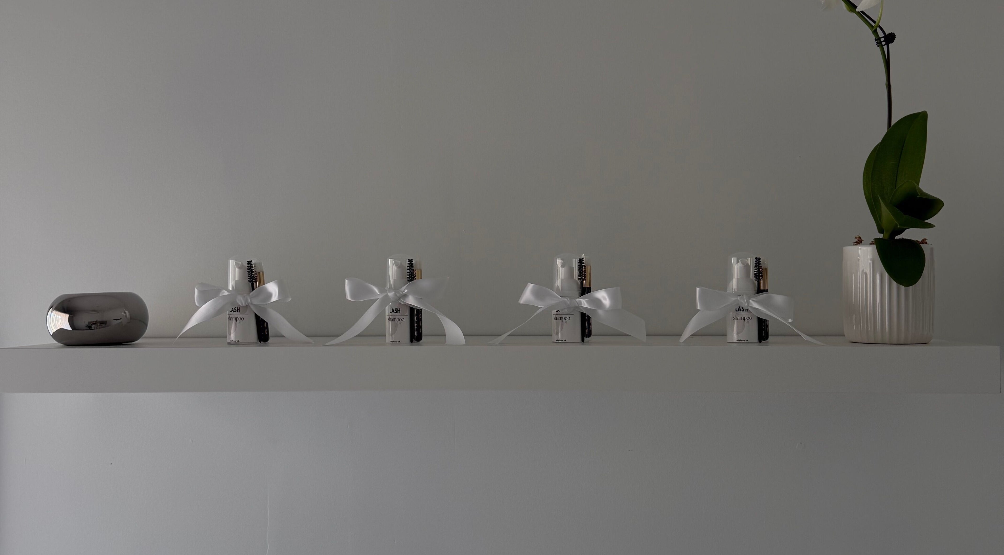 Elegant shelf at Wildflower Ink, Mount Hawthorn, Western Australia, with beauty kits and an orchid arrangement.