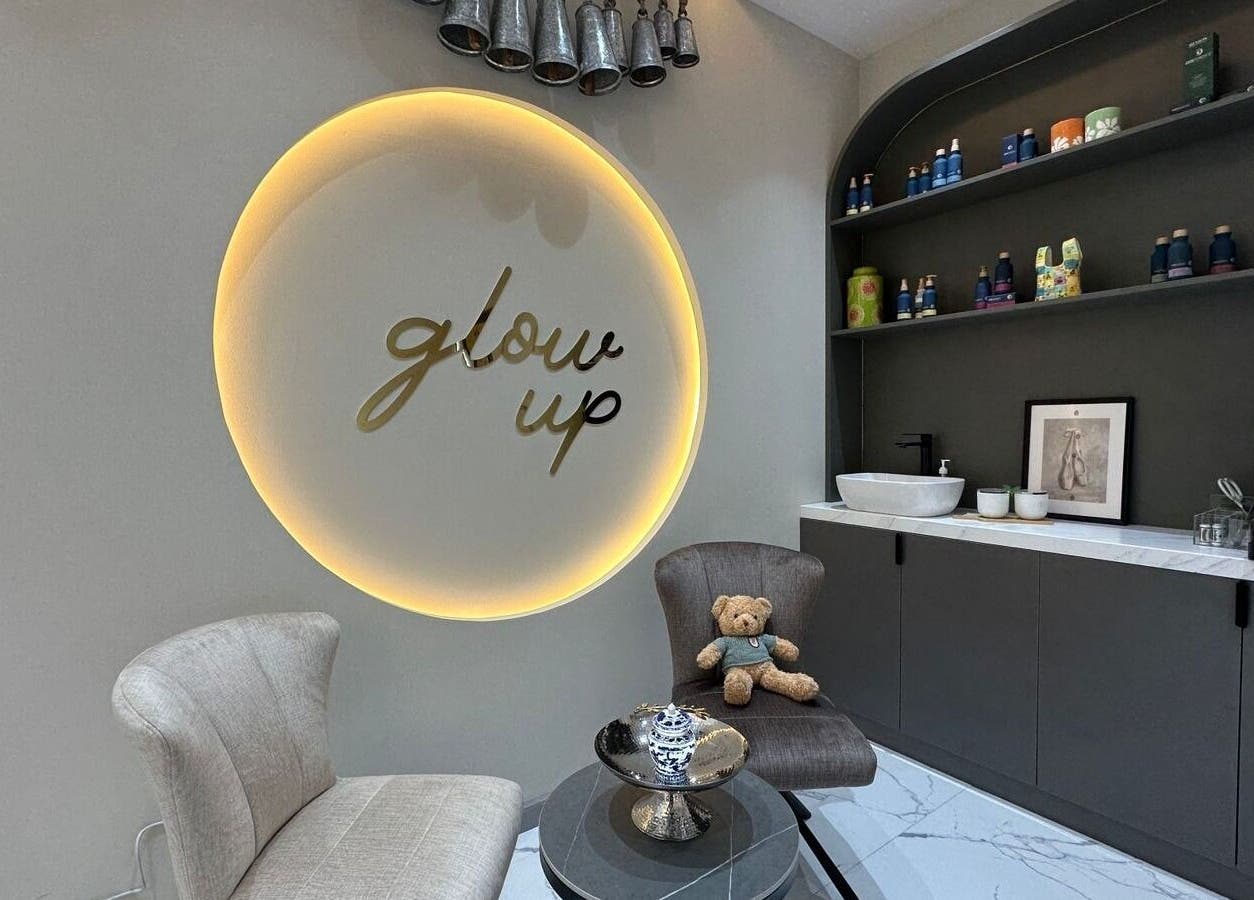 Cozy seating area at Allenora Beauty Lounge, Abu Dhabi, AE, with 'glow up' sign on wall.