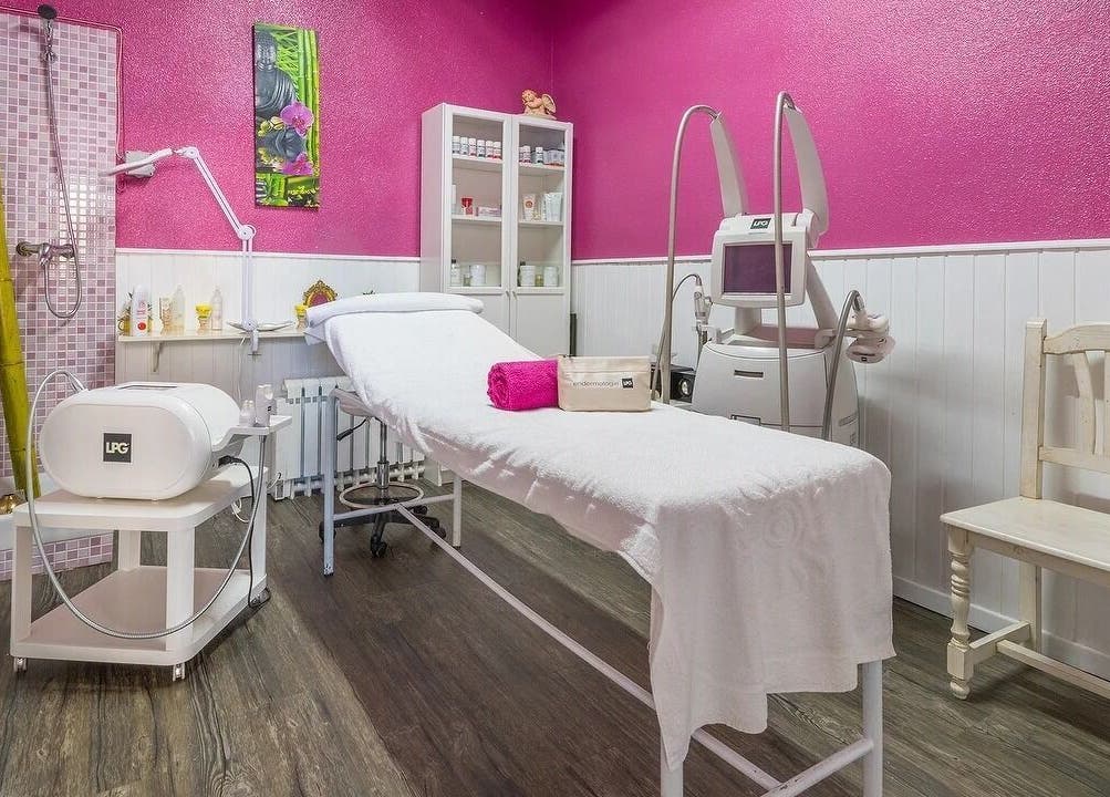 Sala de tratamiento en Belleza Integral 10 VD, Madrid, con paredes rosas y equipo de belleza.