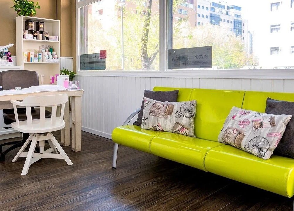 Sala moderna y luminosa en Belleza Integral 10 VD, Madrid, Comunidad De Madrid, ES con sofá verde y mesa blanca.