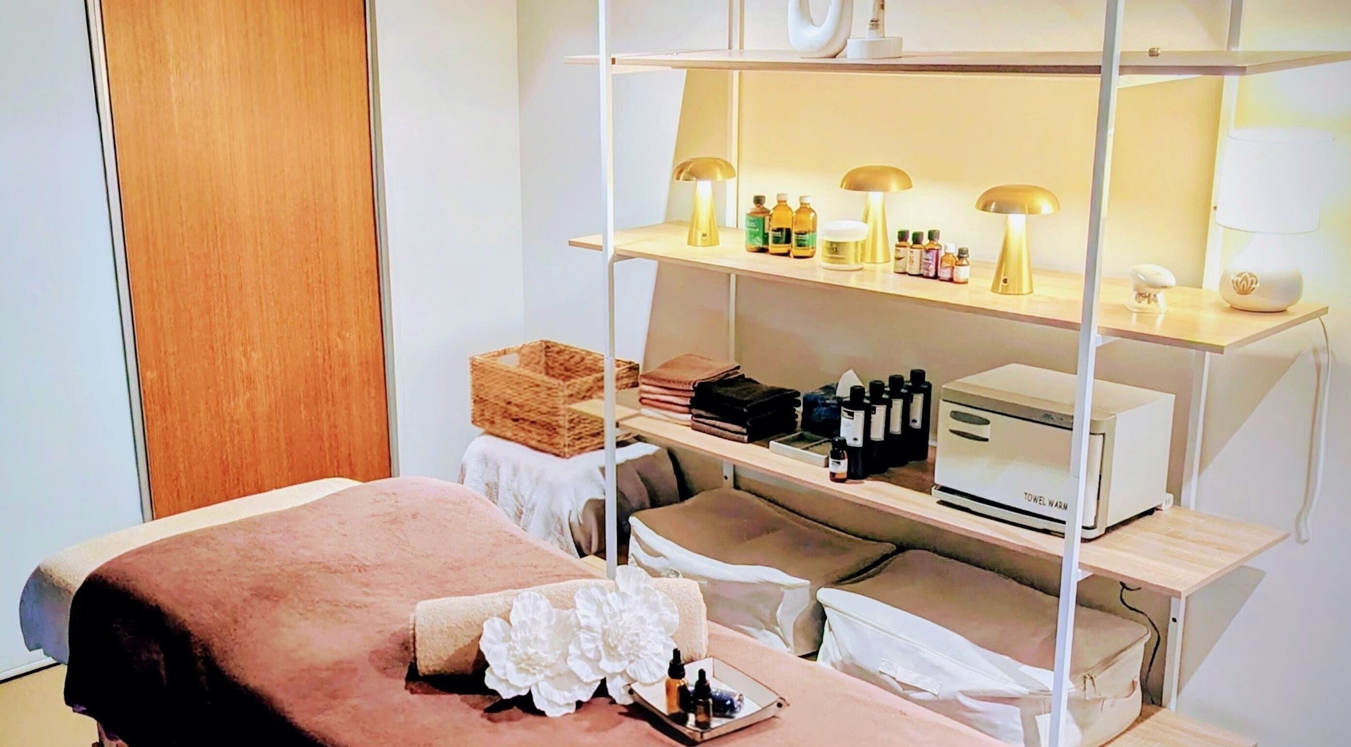Cozy treatment room at Total Body Care Salon BLESS, Auckland, NZ with essential oils and warm lighting.