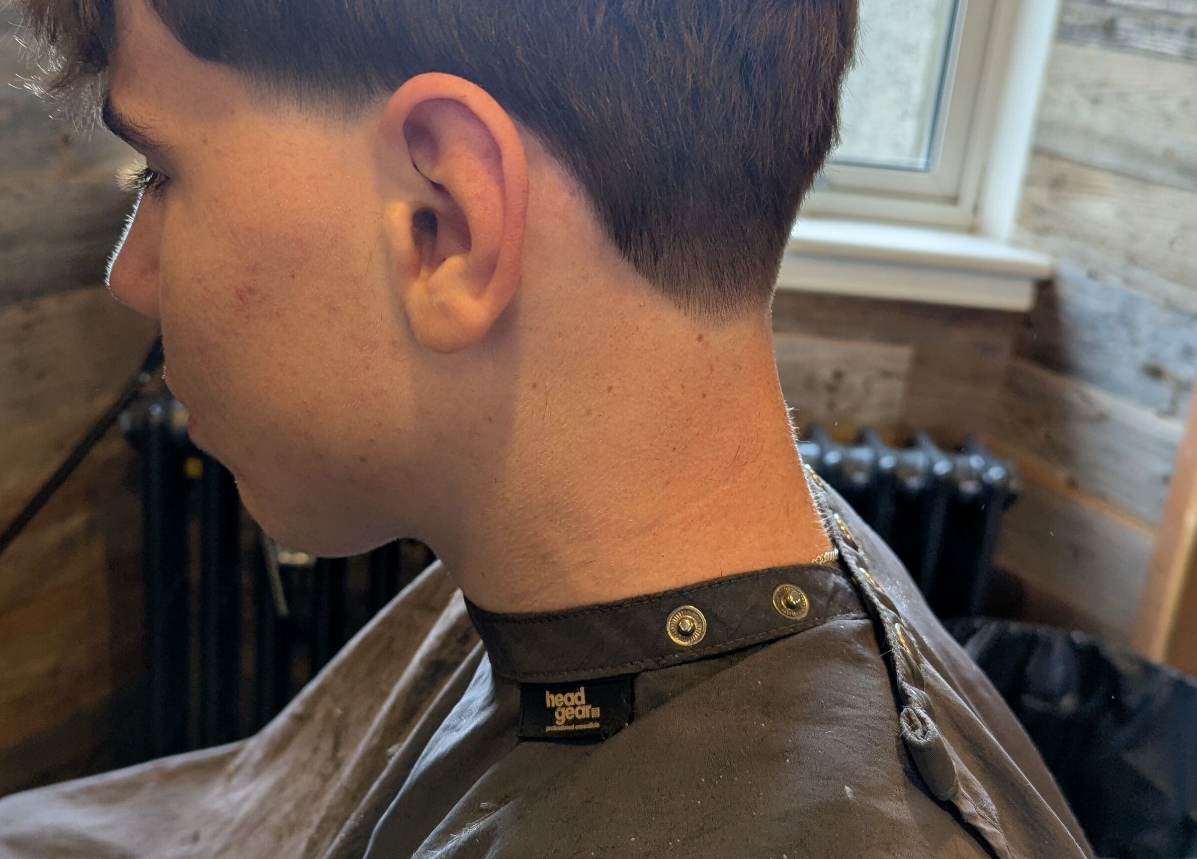 Side profile of a man with a fresh taper cut at JW BARBERING, Pembroke, Wales, GB.