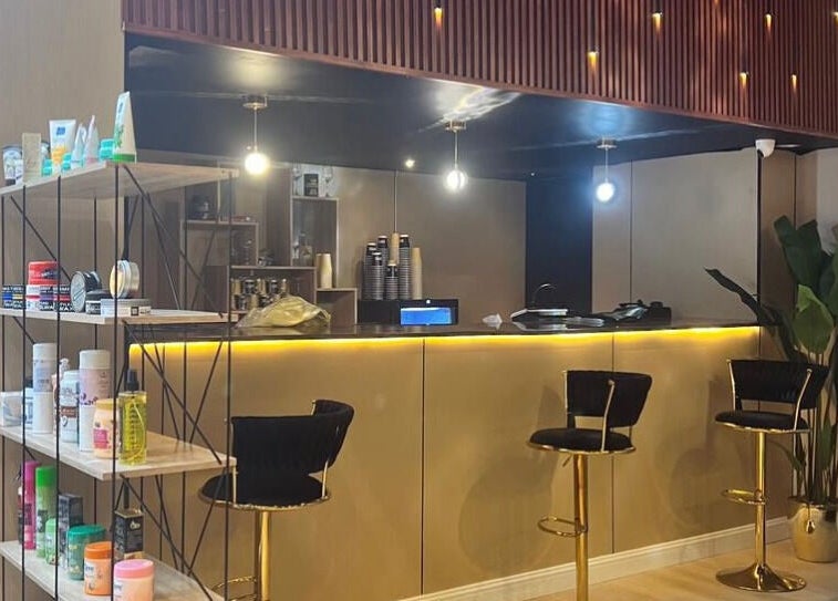 Chic interior of Billionaire Salon – Al Shati, Jeddah, showcasing elegant bar stools and beauty products.