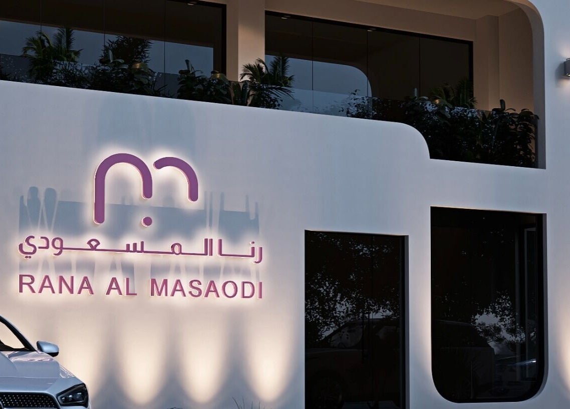 واجهة مشغل و صالون رنا المسعودي للتزيين النسائي ابها، عسي، مضاءة بشكل أنيق في الليل.
