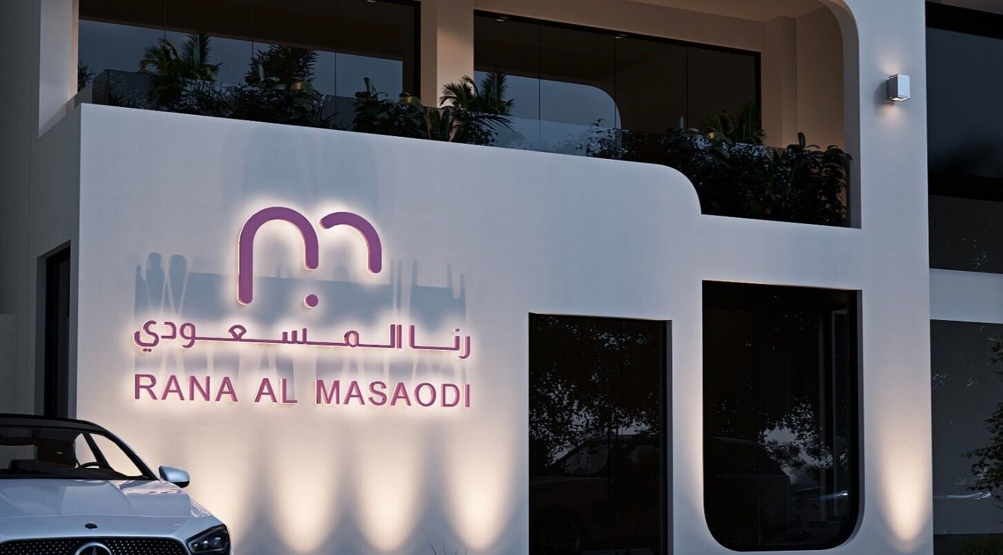 واجهة مشغل و صالون رنا المسعودي للتزيين النسائي ابها، عسي، مضاءة بشكل أنيق في الليل.