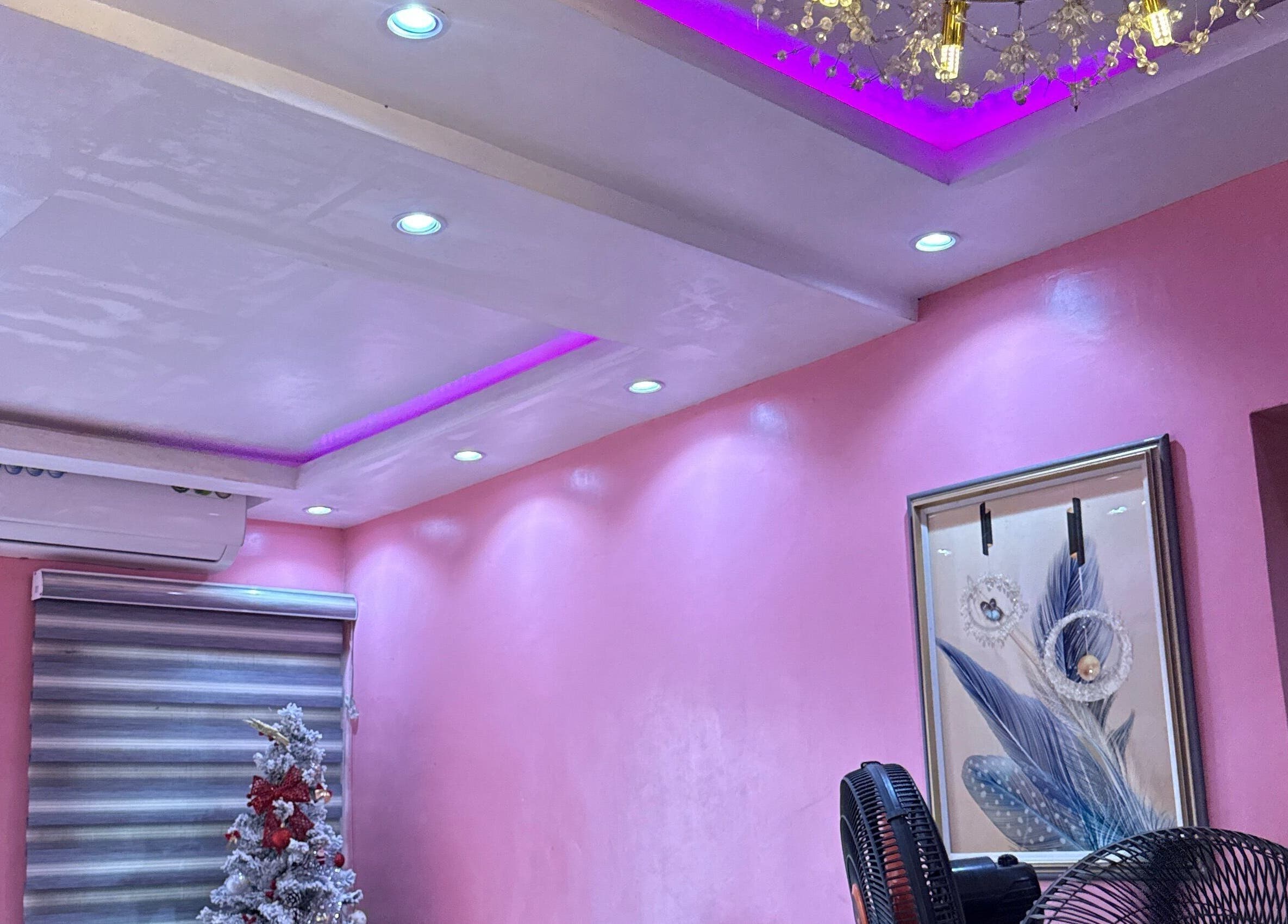 Stylish pink interior of Nailzby.ola in Lagos, Lagos, NG with elegant decor and unique lighting.