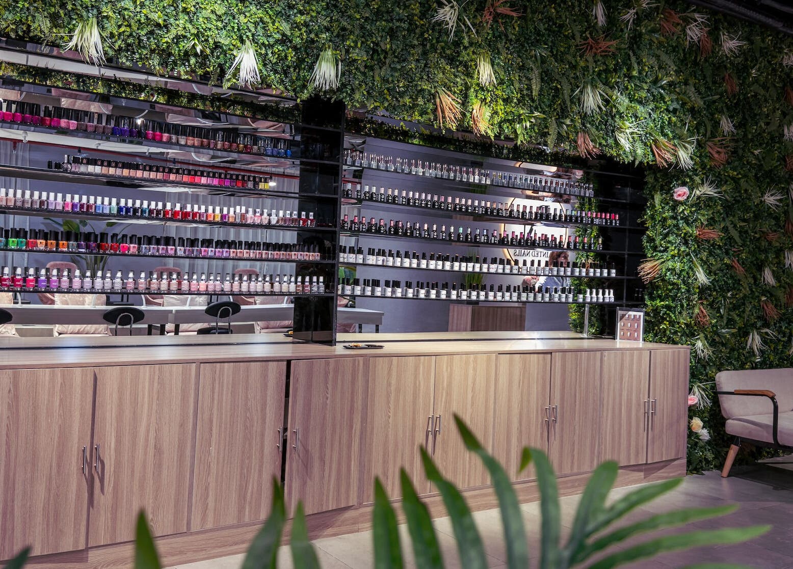 Stylish nail polish display at Painted Nails Beauty Salon in Abu Dhabi, AE amidst lush greenery.