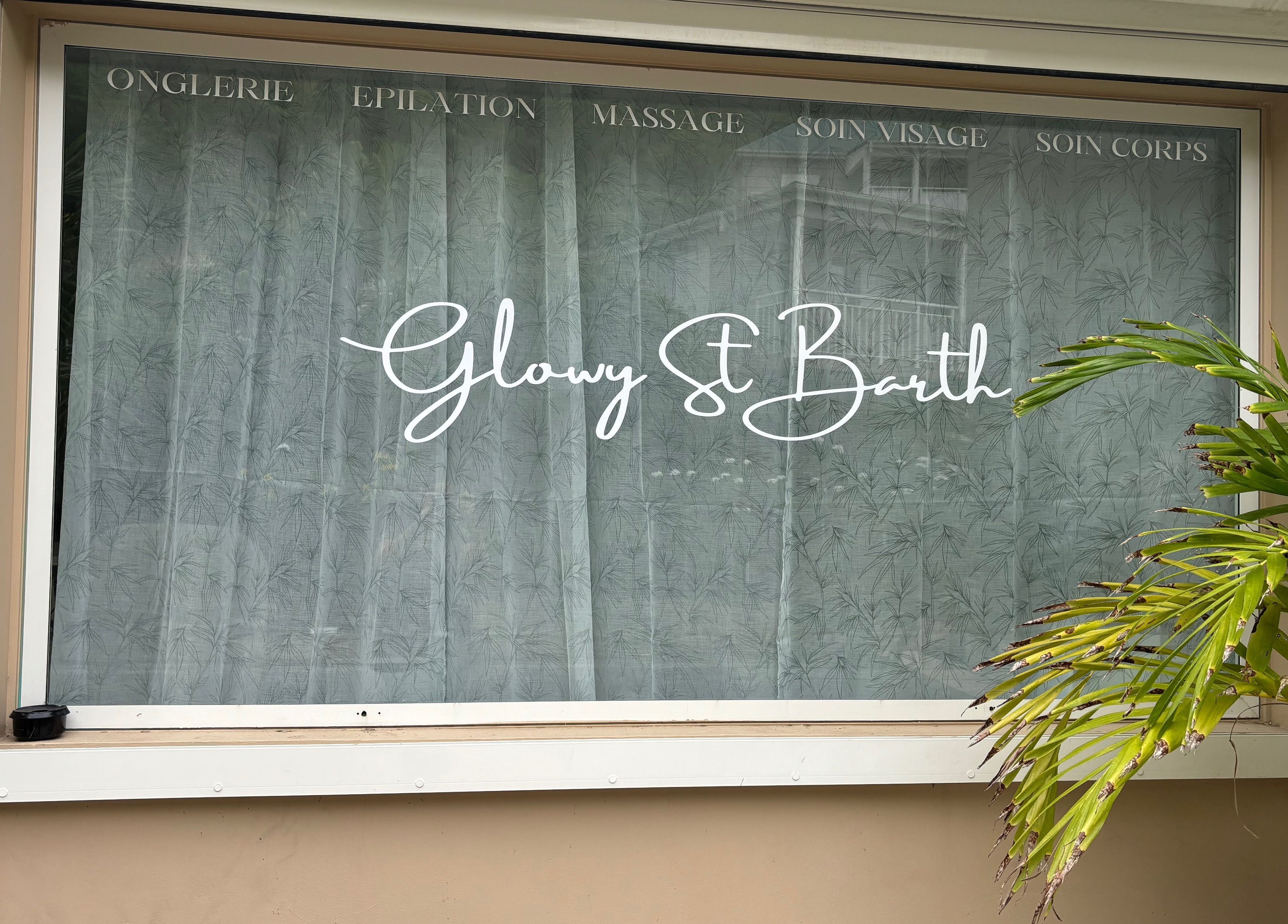 Vitrine du Glowy St Barth à Saint-Barthélemy, arborant le logo élégant et feuillage tropical.