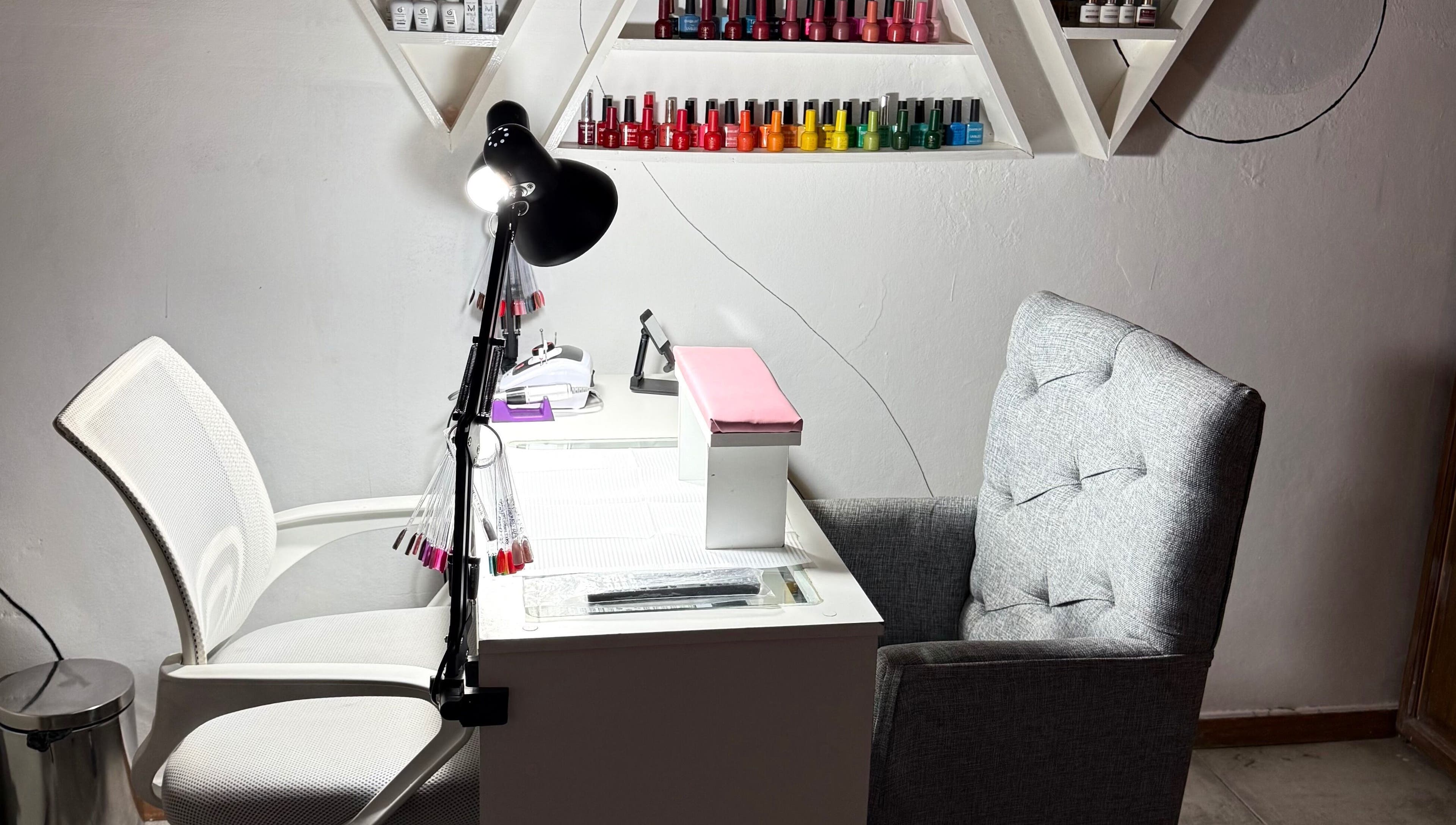 Estación de manicura en Almabella, Mendoza, Mendoza, AR, con sillas cómodas y esmaltes en estante.