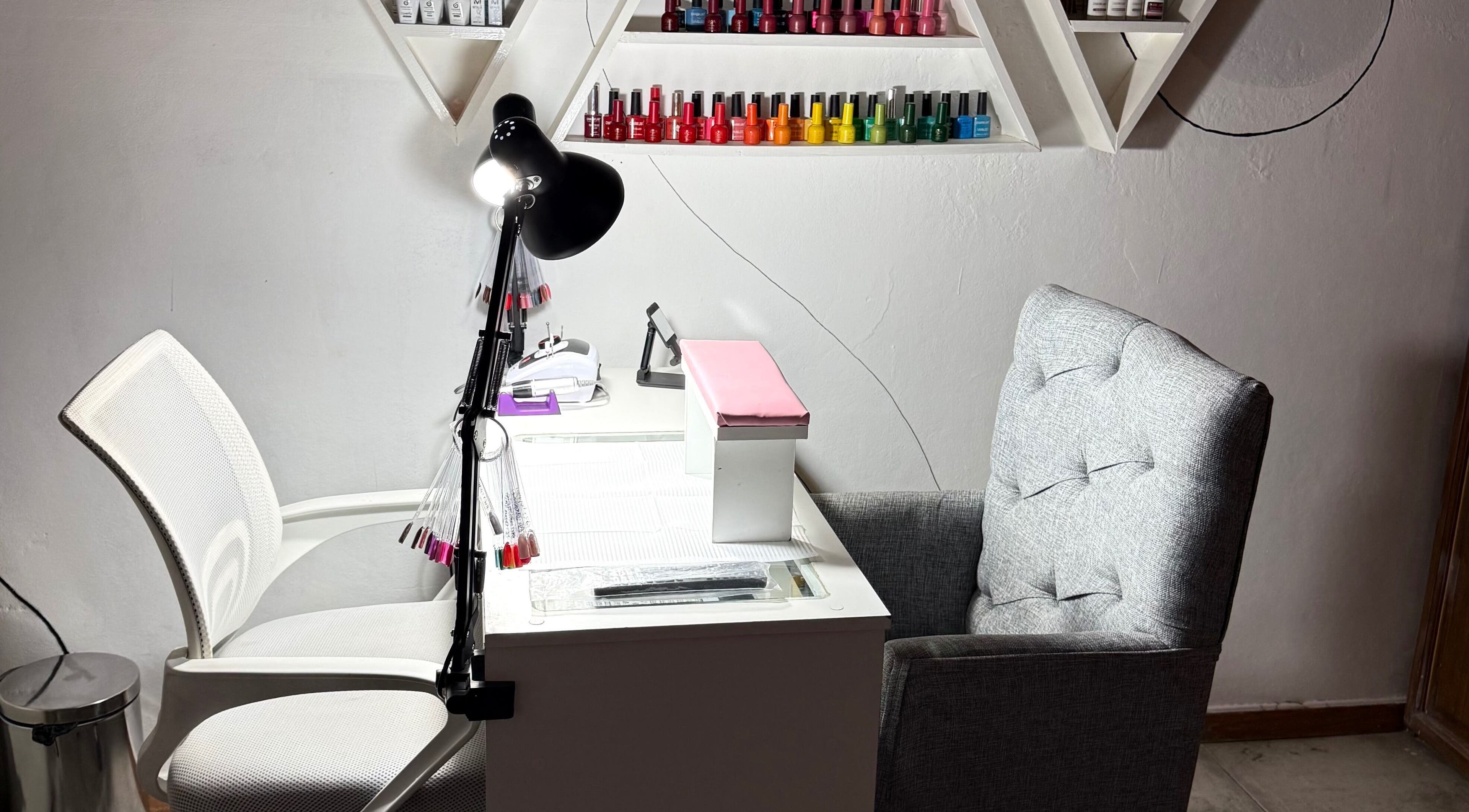Estación de manicura en Almabella, Mendoza, Mendoza, AR, con sillas cómodas y esmaltes en estante.