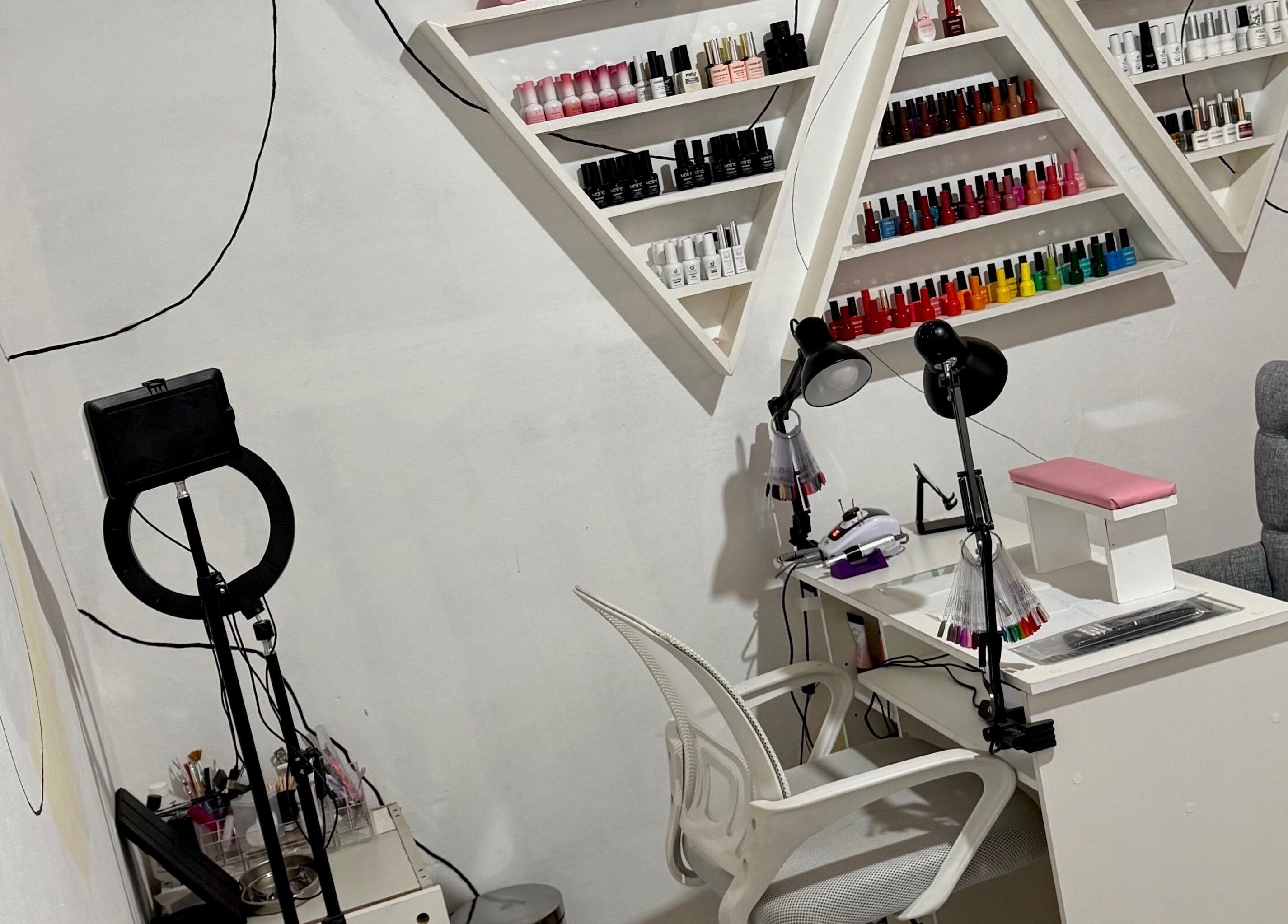 Mesa de manicura en Almabella, Mendoza, Mendoza, AR con esmaltes coloridos en estantes triangulares.