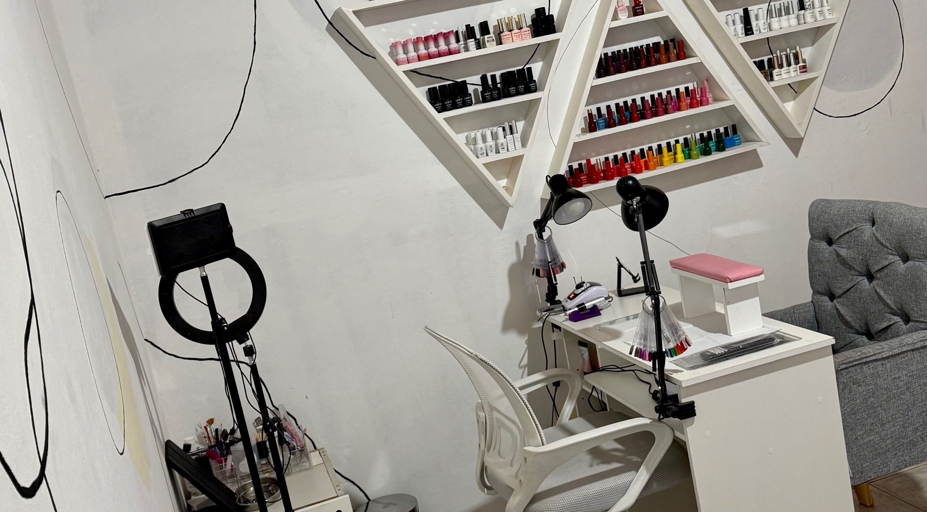 Mesa de manicura en Almabella, Mendoza, Mendoza, AR con esmaltes coloridos en estantes triangulares.