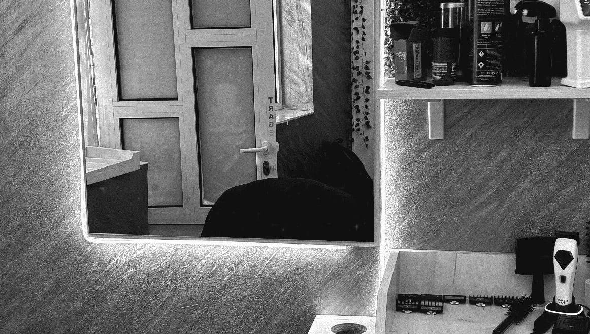 Cozy interior of Cristea the Barber in Râmnicu Sărat, Județul Buzău, RO showcasing grooming tools and mirror.