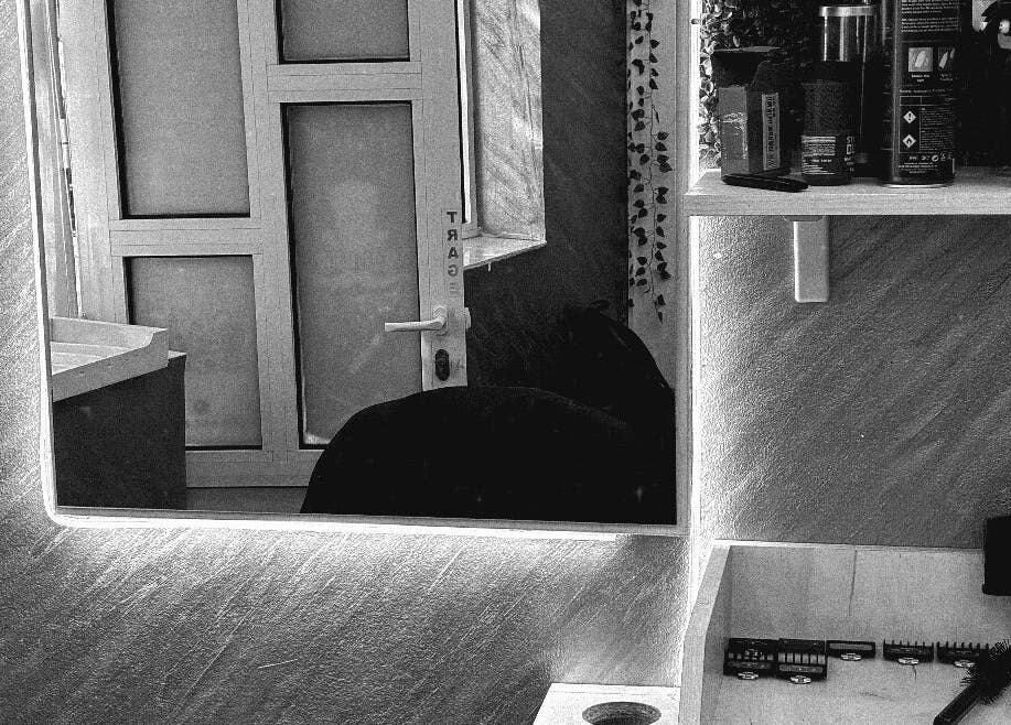 Cozy interior of Cristea the Barber in Râmnicu Sărat, Județul Buzău, RO showcasing grooming tools and mirror.