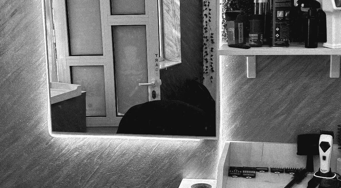 Cozy interior of Cristea the Barber in Râmnicu Sărat, Județul Buzău, RO showcasing grooming tools and mirror.