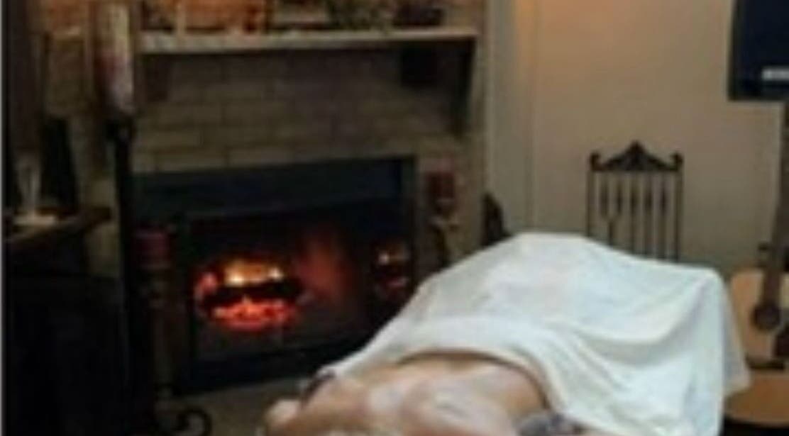 Sesión de masaje en Awakening Bliss, Rionegro, Antioquia, CO, junto a una acogedora chimenea.