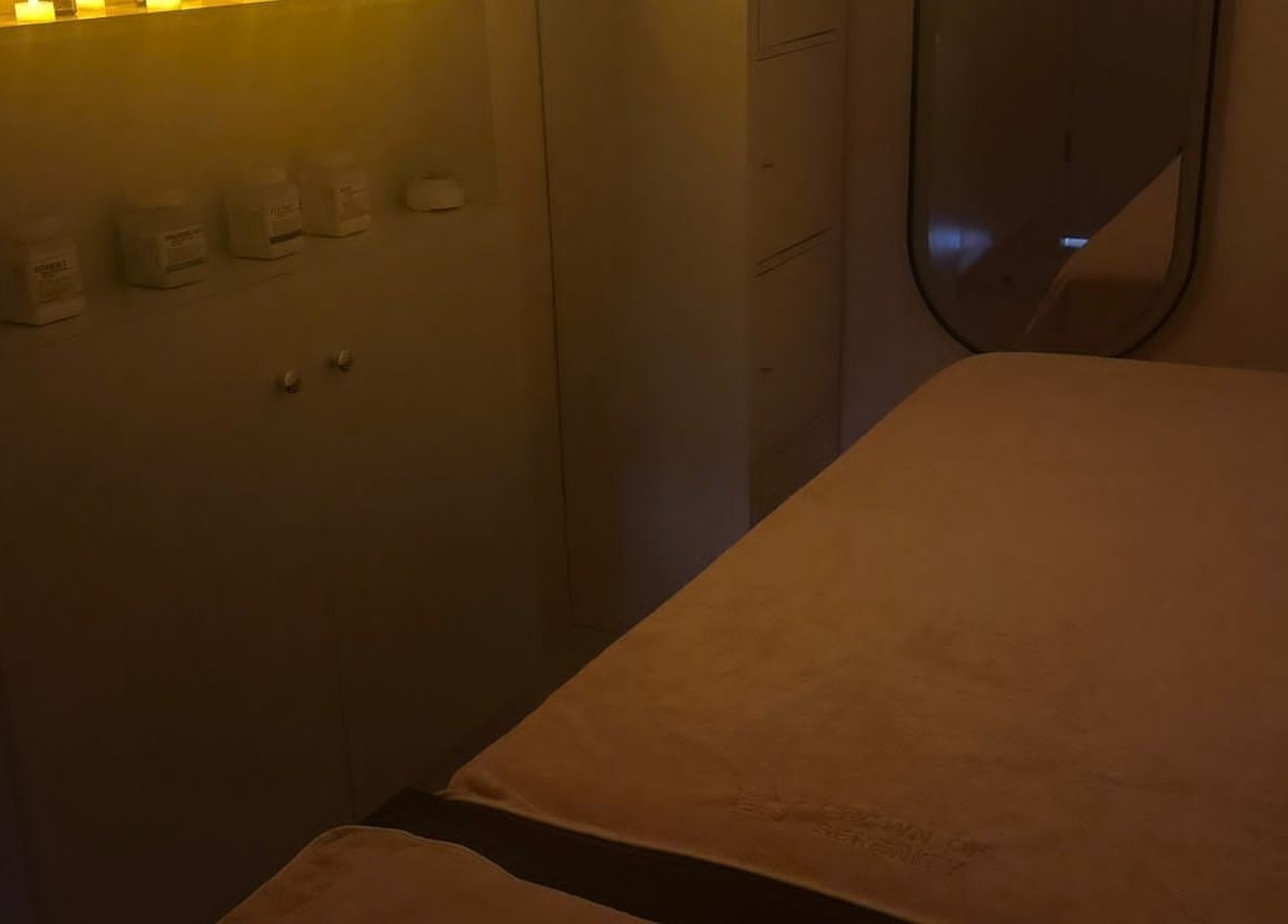 A serene massage room at Crown of Serenity in Dubai, Dubai, AE, featuring a cozy bed under warm ambient lights.