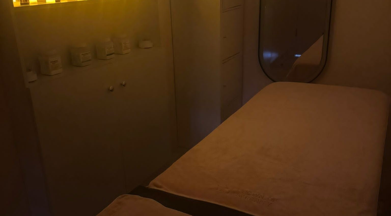 A serene massage room at Crown of Serenity in Dubai, Dubai, AE, featuring a cozy bed under warm ambient lights.