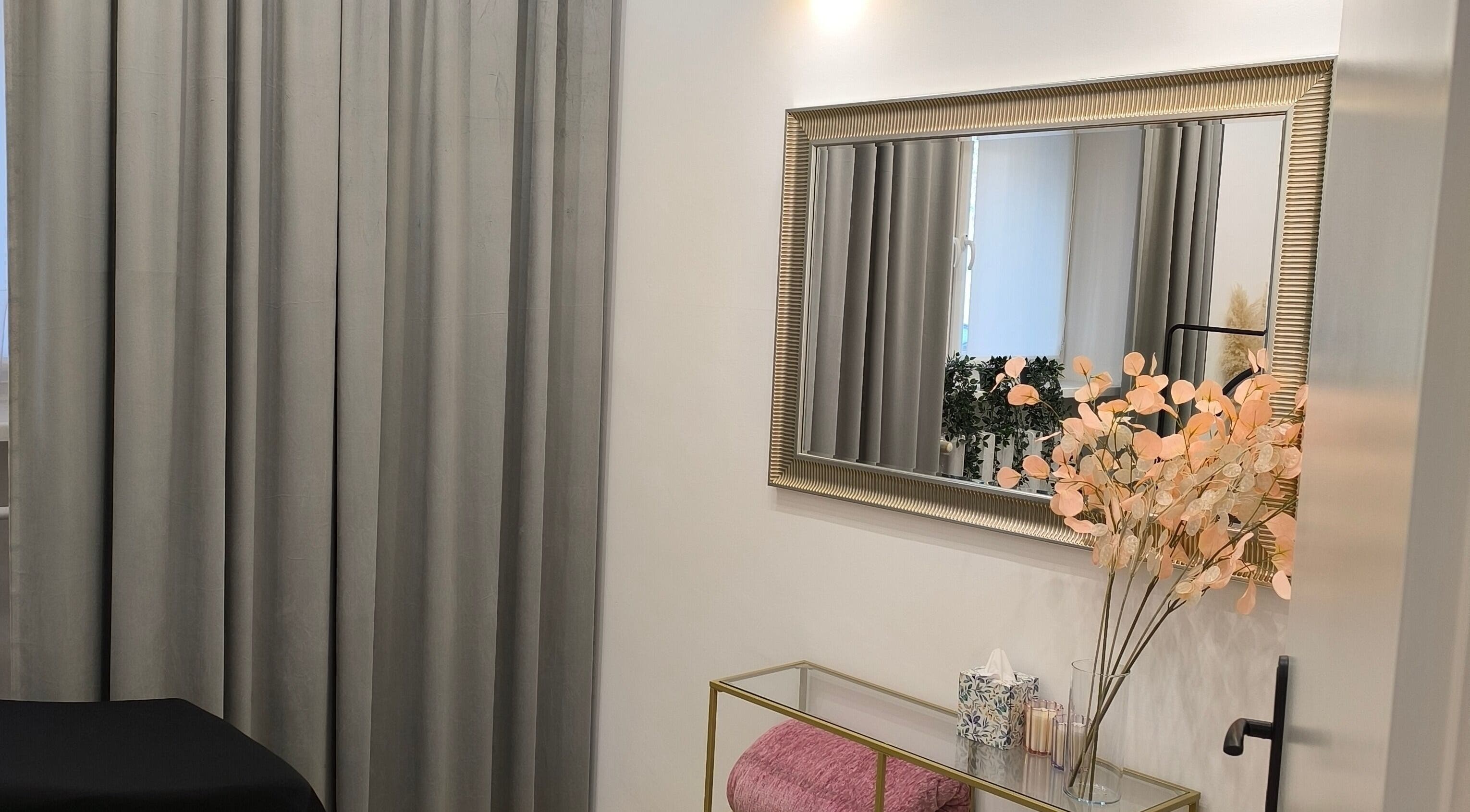 Przytulne wnętrze SUGAR Lashes & Brows w Krakowie, Województwo Małopolskie, PL z lustrem i dekoracjami.